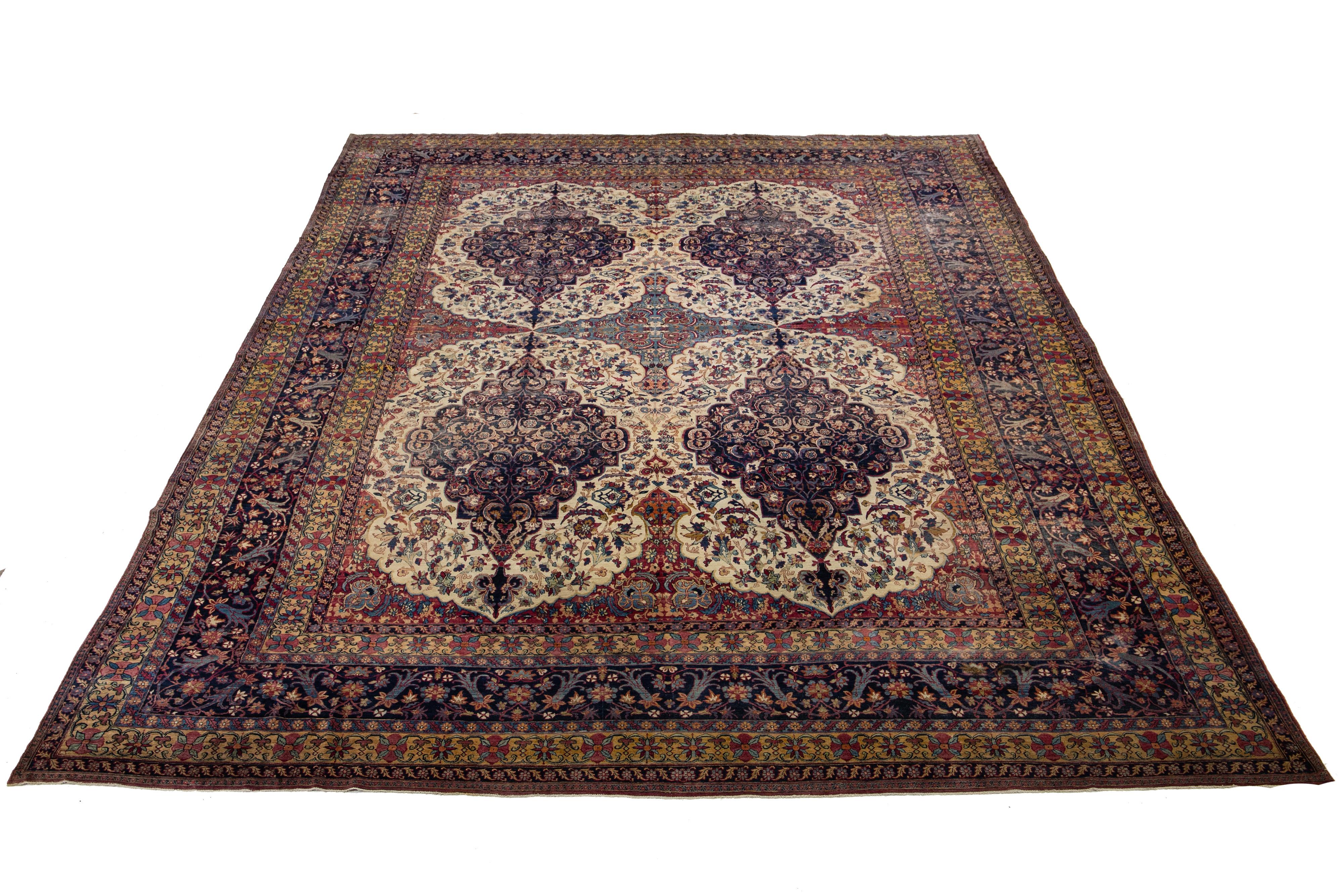 Dieser übergroße, handgeknüpfte Wollteppich ist eine außergewöhnliche Antiquität mit einem lebhaften Blumenmuster in verschiedenen Farben, das einen schönen Kontrast zu seinem tiefblauen und roten Hintergrund bildet.

Dieser Teppich misst 15'2