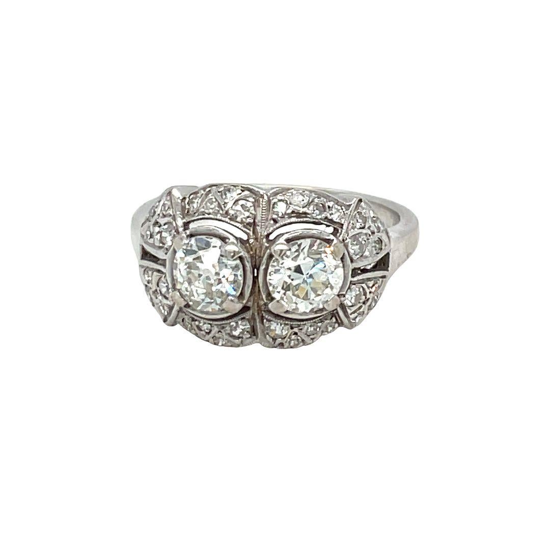 Stunning Art Deco ring centered with two old European cut diamonds .60 carat each with G-H color and VS clarity and accented with small diamonds in 14K White Gold. Total diamond weight is approximately 1.50 carat. The ring is currently in a size 6.5
