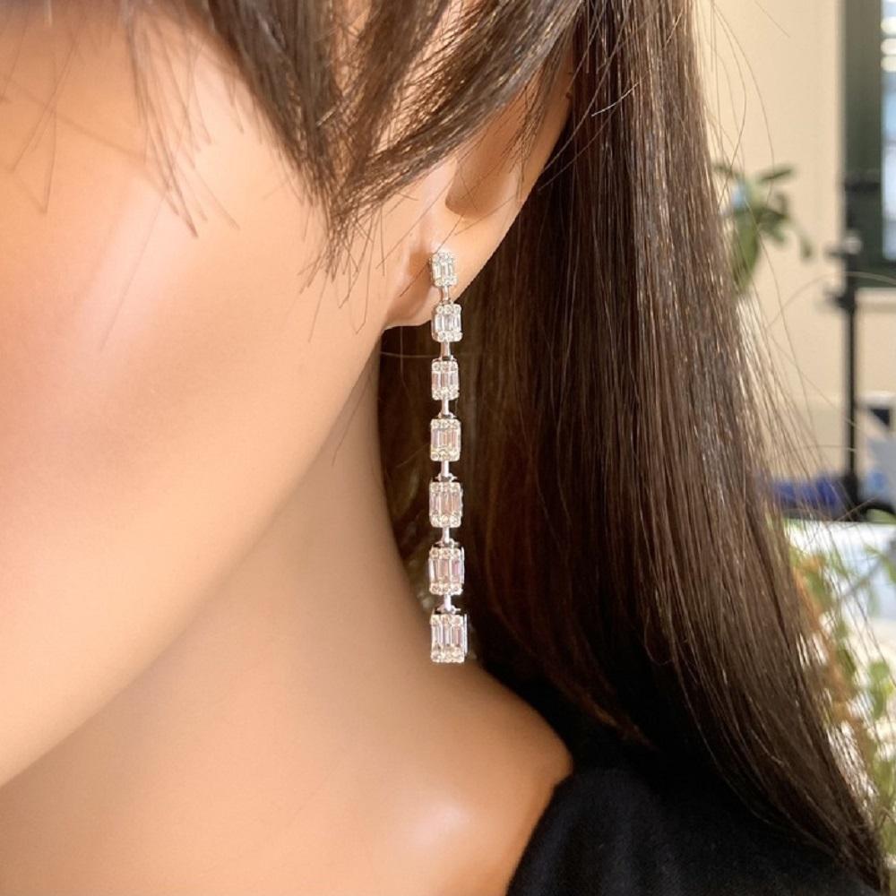 Baguette-cut diamonds as the main stones with a total weight of 1.50 carats. Additionally, there are round diamonds serving as side stones, with a total quantity of 84. The setting for these earrings is made of 18k white gold.