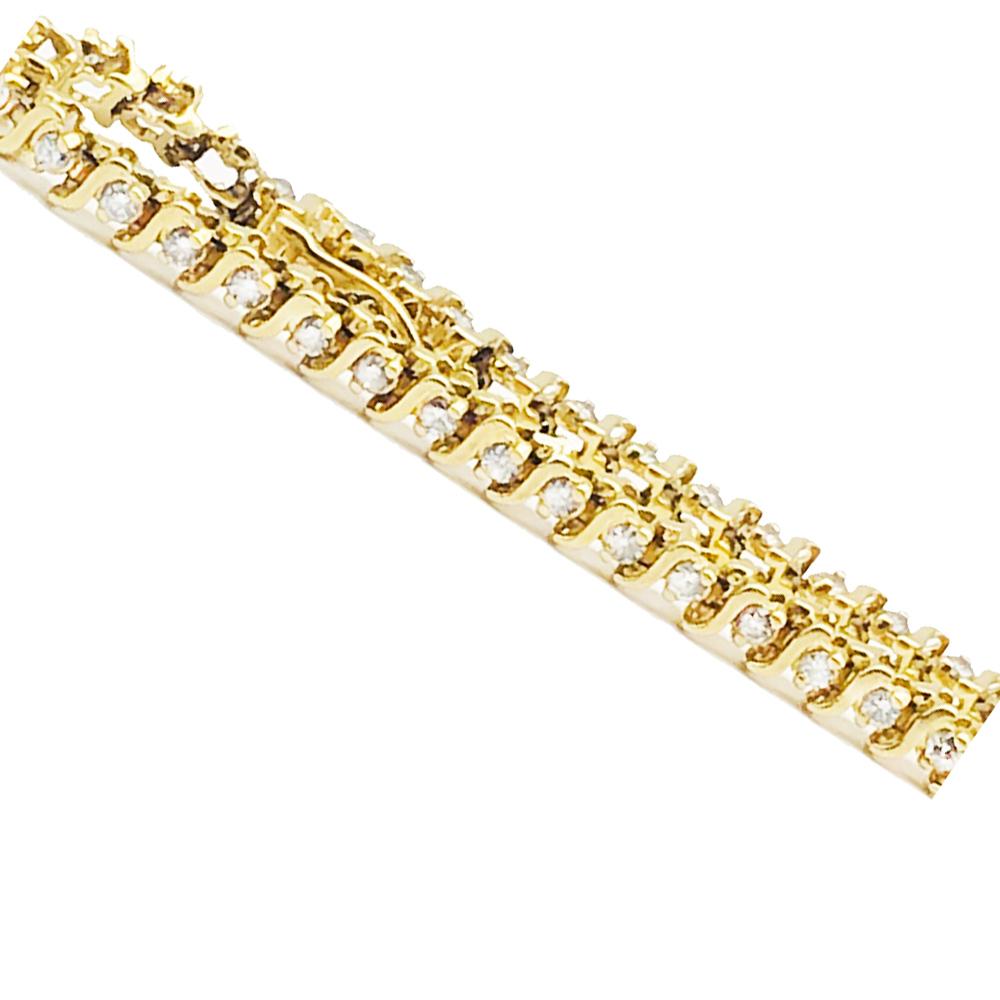 Bracciale tennis con diamanti, stile contemporaneo, realizzato in oro giallo 14 carati 
Si tratta di una maglia a S composta da (29) diamanti.  incastonati in rebbi e misurano 1,96 mm ciascuno. 
Il peso totale dei diamanti è di 1,50 carati.
 La
