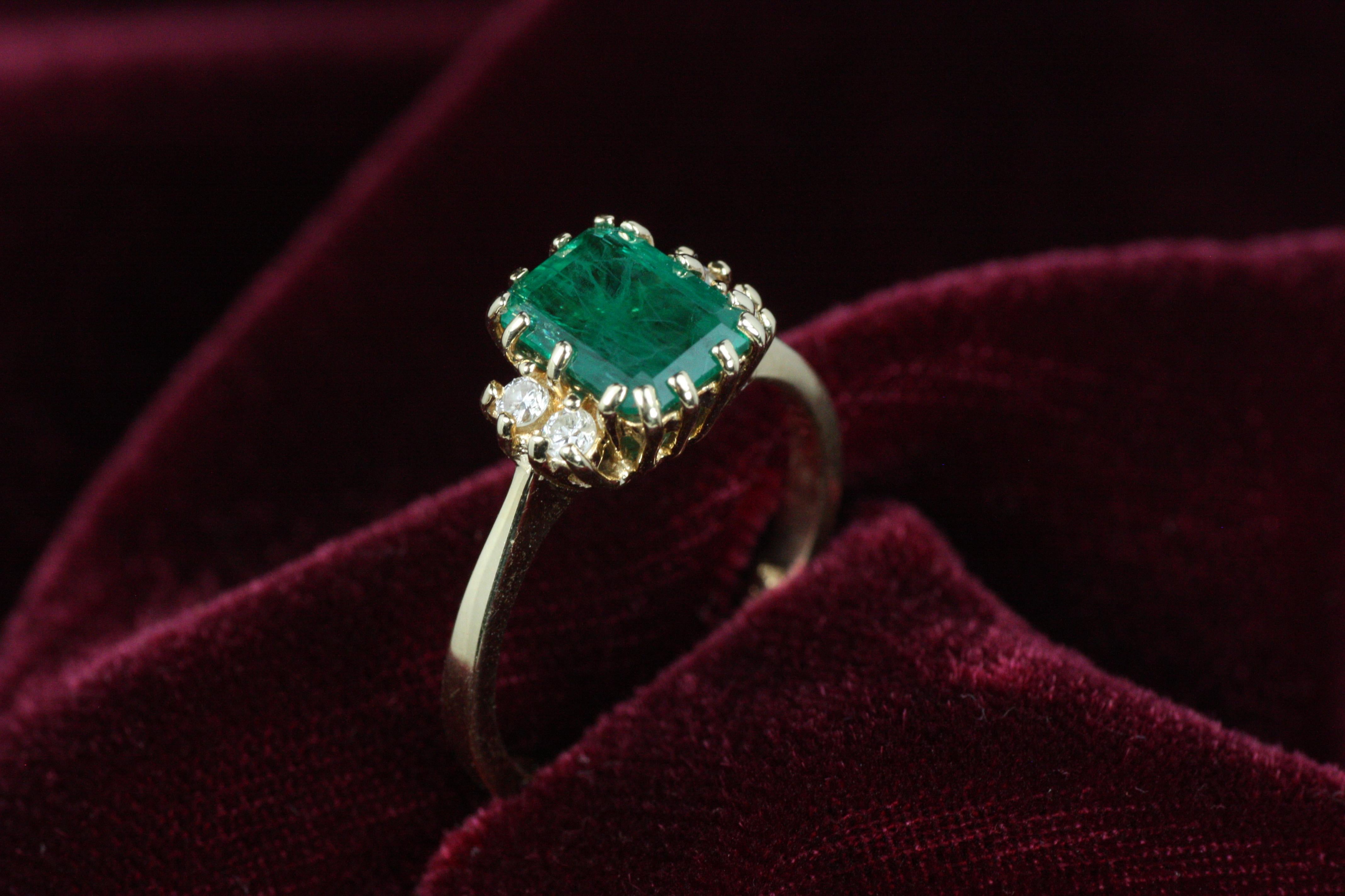 Un anillo clásico e intemporal de esmeralda y diamantes en oro amarillo de 14 quilates de nuestra moderna colección de joyería de lujo de Bracken Jewelers. La protagonista de este anillo es la esmeralda natural de Colombia de aproximadamente 1,50