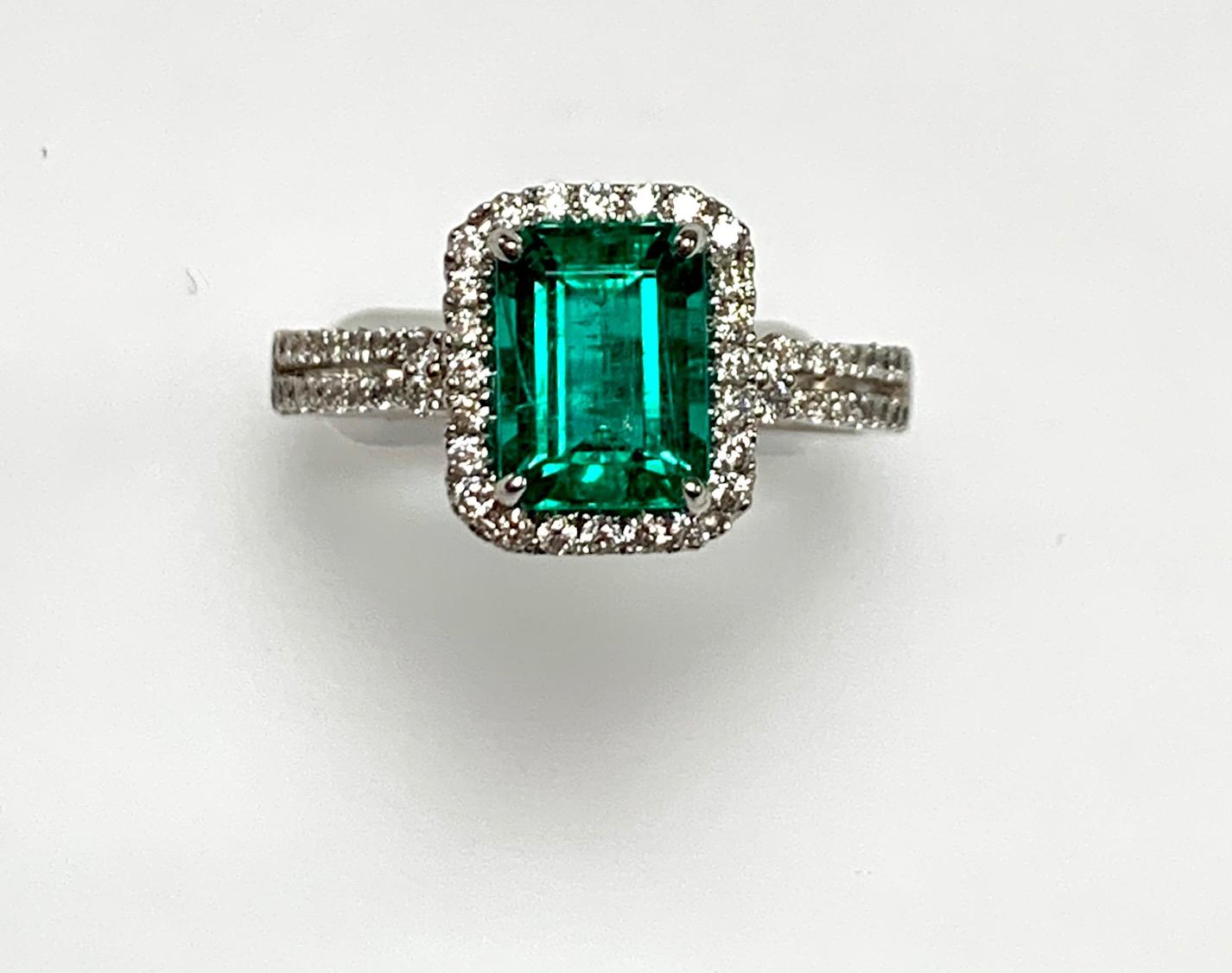1.50 Carat Emerlad cut  emerald , zambian , set in 18k white gold ring with 0.48 carat of round diamonds around it and on the half way on split shank .
