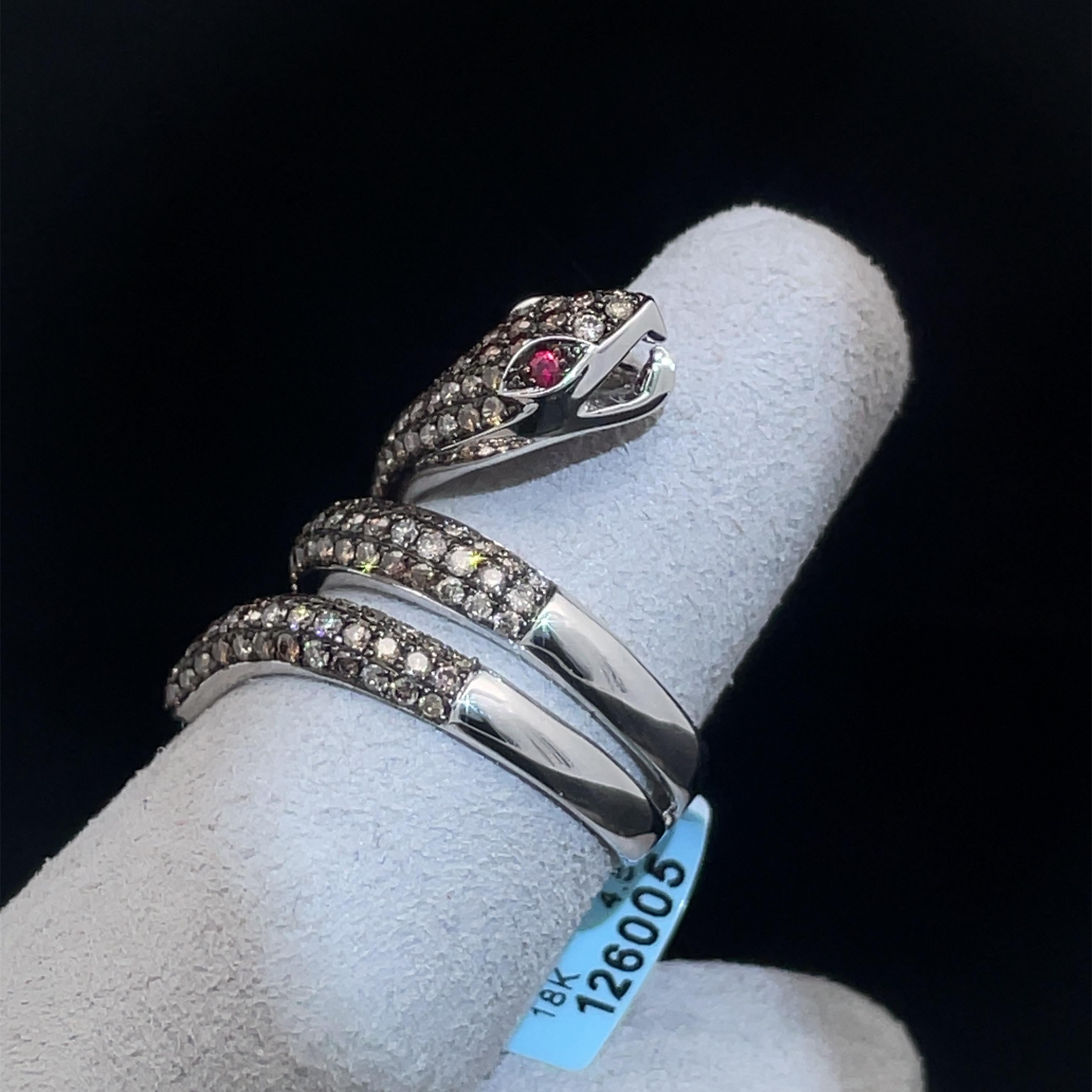 Slither into glamorous style with this brightly polished 18k white gold coiled snake serpent ring. Sparkling round brilliant cut fancy brown diamonds pave set on the ring with natural ruby eyes turn up the luxury to this enchanting and magical