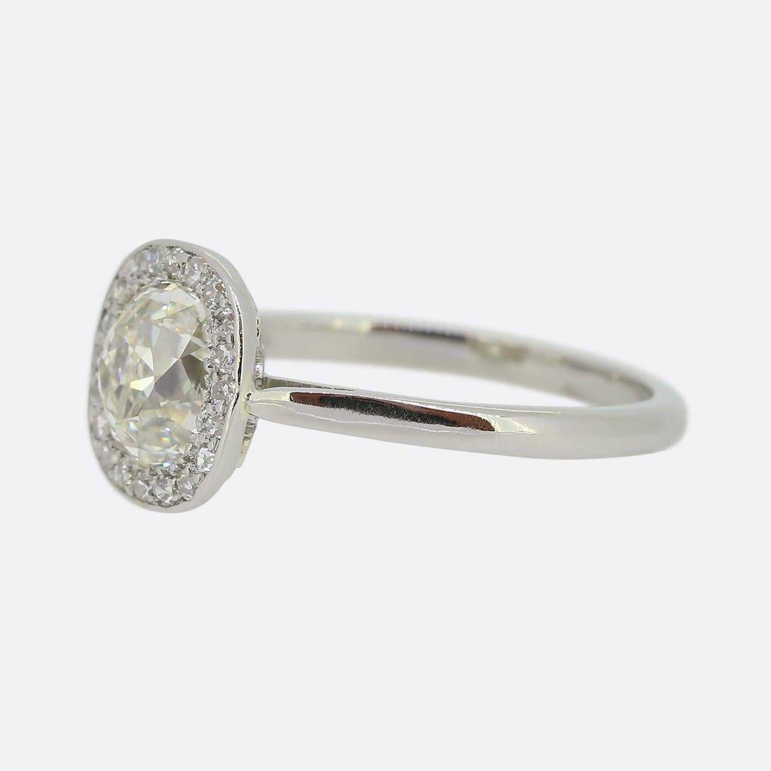 This is a wonderful platinum diamond engagement ring. The centre stone is a 1.50 carat old mine that would have been cut by hand near the turn of the 19th to the 20th century, it has wide facets that create bold and vibrant sparkle as well as vivid