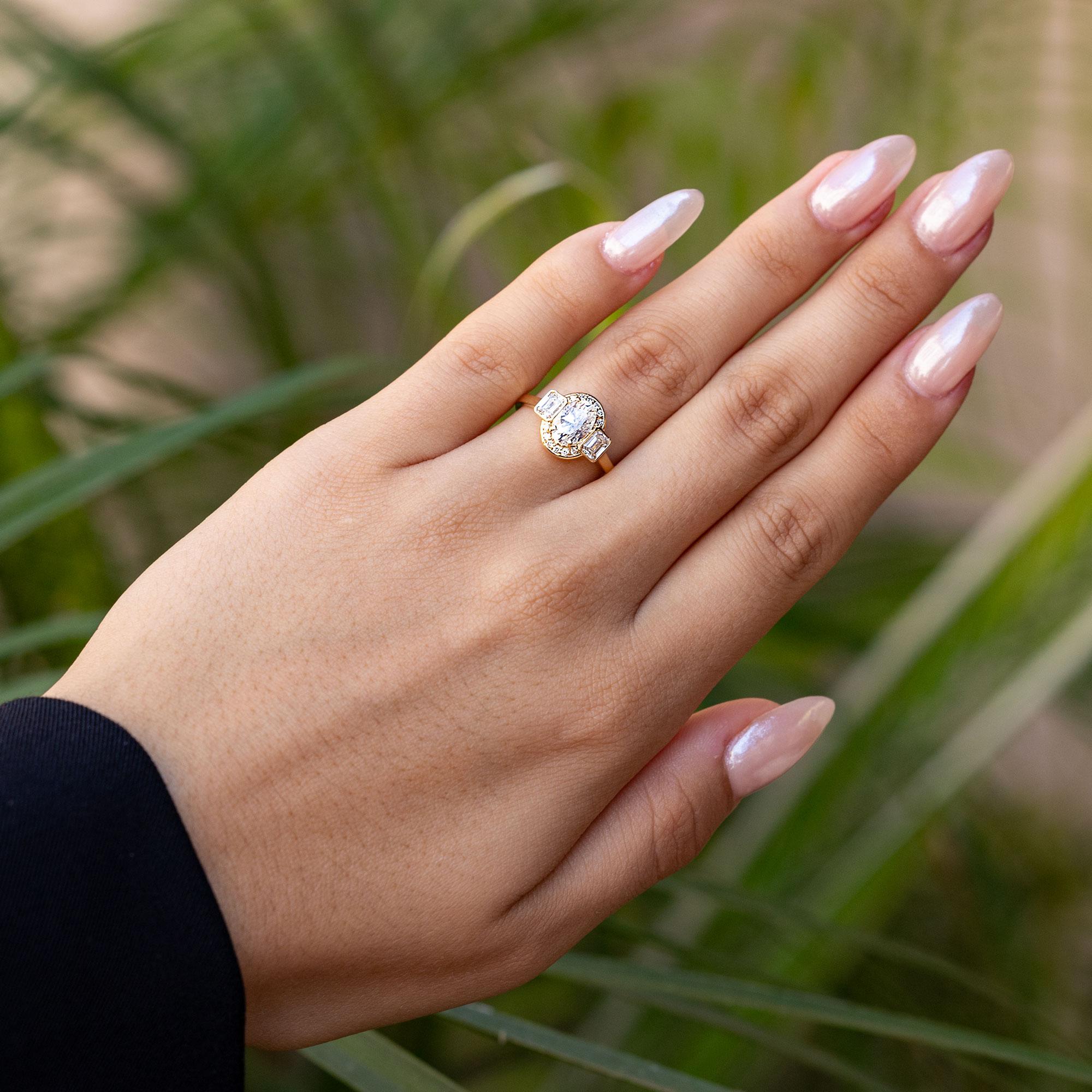 A luxurious natural diamond engagement ring, this authentic revival of the fantastic art deco era of the 1920s glows with such a lively and unique charm. The striking central 1.08 carat oval diamond is expertly faceted, emanating a vibrant sparkle.