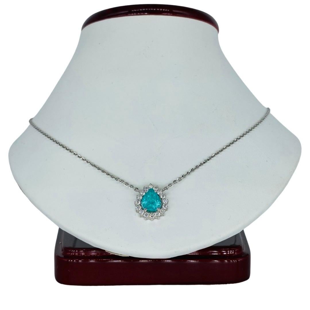 Vintage 1.75 Carat Paraiba Tourmaline measuring approx 8.15mm X 6.77mm X 5.57mm and Diamonds surrounding the gemstone weight approx 0.50 total carat weight. Very nice Pendant Necklace. The necklace is 18 inches long and weights 5.4 grams made in 18k