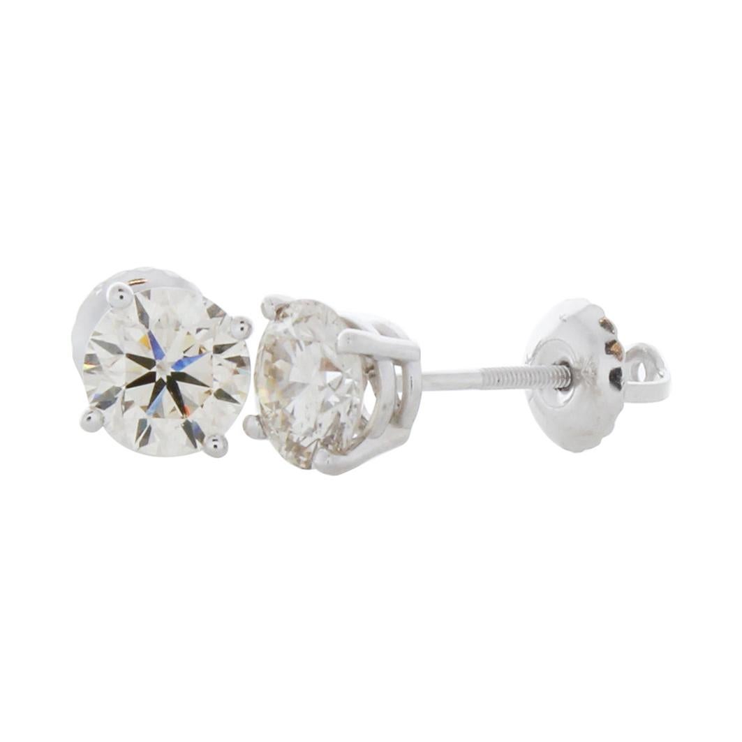 Stunning 14 Karat white gold handmade earrings featuring 2 round brilliant cut diamonds weighing 1.50 carat total I-J color and I1 clarity. The stunning earrings measure 5.50mm in diameter, these gorgeous earrings are classic and timelessly elegant.