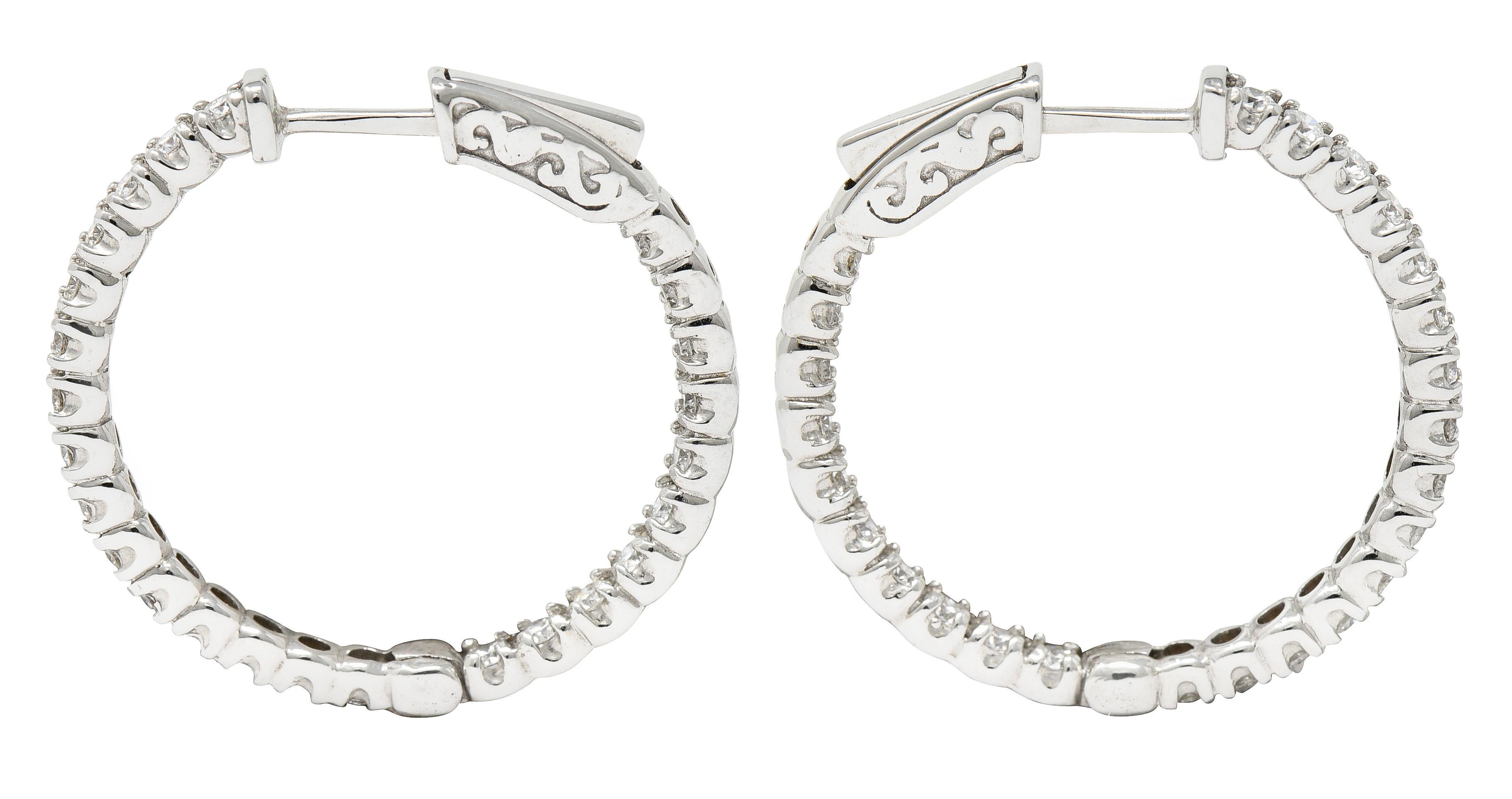 Inside/outside style huggie hoop earrings

With individually set round brilliant cut diamonds

Weighing in total approximately 1.50 carats - G/H color with overall VS clarity

Opens on a hinge via presser revealing posts

Inscribed with carat