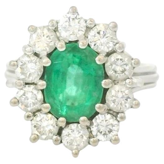 1.50 Carats oval Emerald and diamond cluster ring For Sale