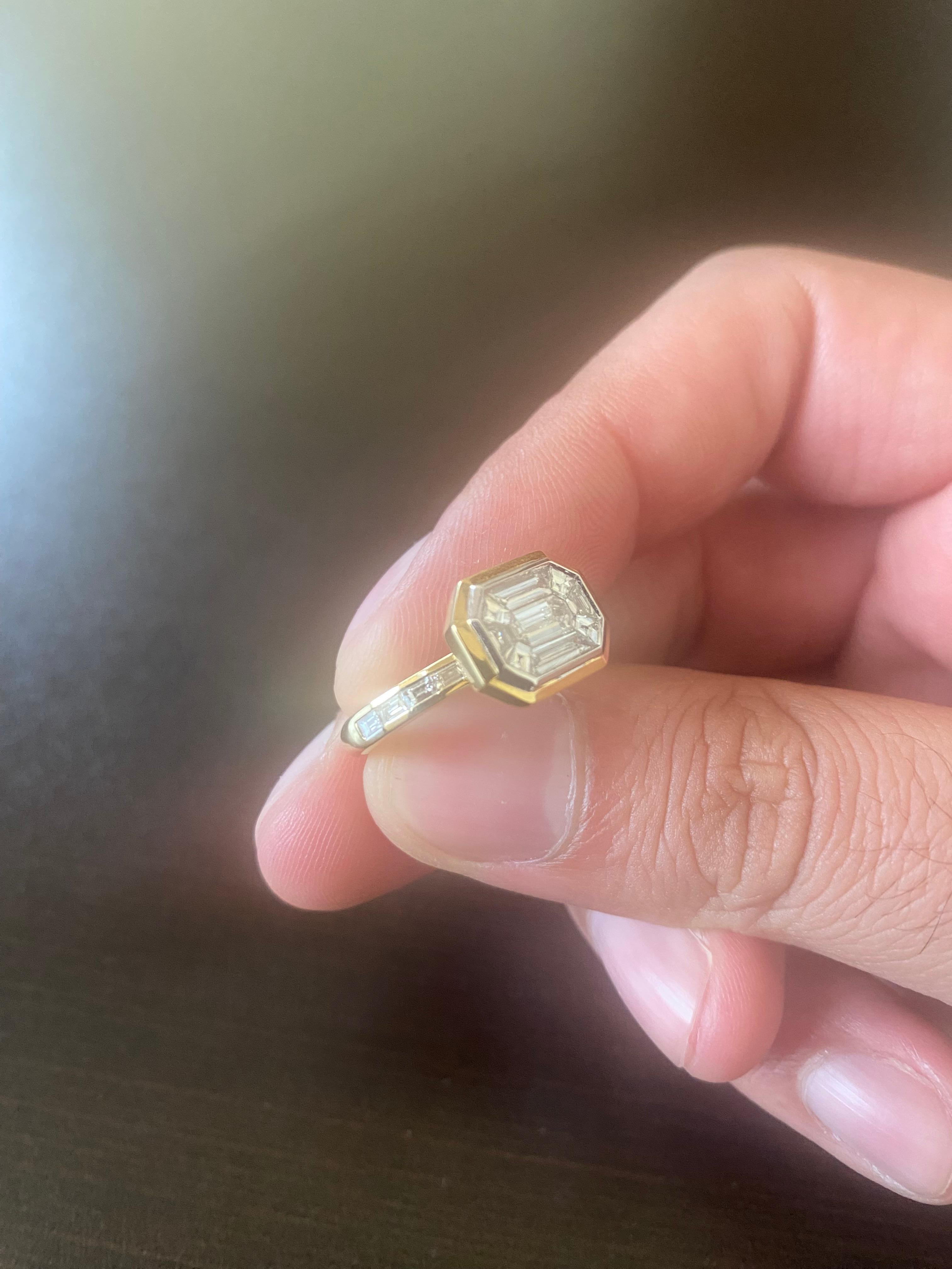 Bague illusion de taille émeraude en or jaune 18K. Le centre est serti d'une grappe d'émeraudes et de diamants trapézoïdaux pour créer l'illusion d'une seule grosse émeraude taillée. La bague est sertie de diamants baguettes sur la tige. La couleur