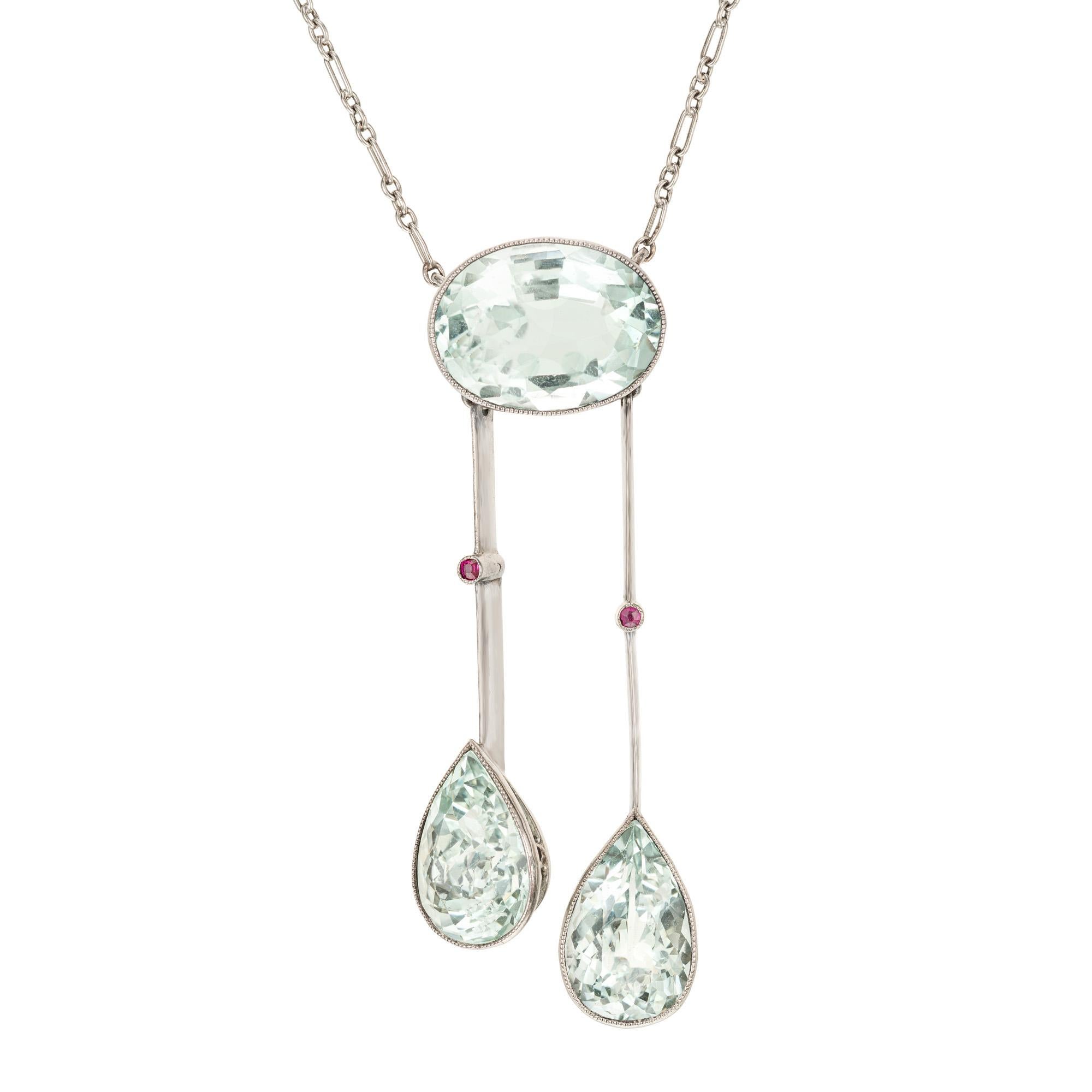 Collana con ciondolo in stile lavaliere Aqua naturale e non trattata. 1 acquamarina ovale incastonata con due pendenti a forma di pera, accentuati da 2 rubini rotondi. I colori dell'acqua sono leggermente verdognoli. Catena in oro bianco da 16
