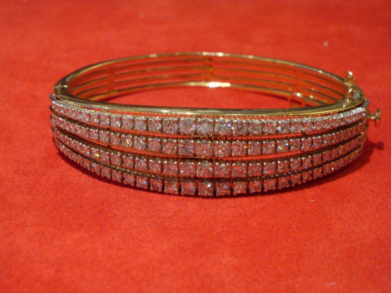 Der folgende Artikel, den wir anbieten, ist dieses seltene Armband aus 14 Kt. Gelbgold und Diamanten, in einem abgestuften vierreihigen Design mit 124 runden Diamanten im Brillantschliff mit einem Gesamtgewicht von ca. 5,00 Karat, mit Scharnieren.