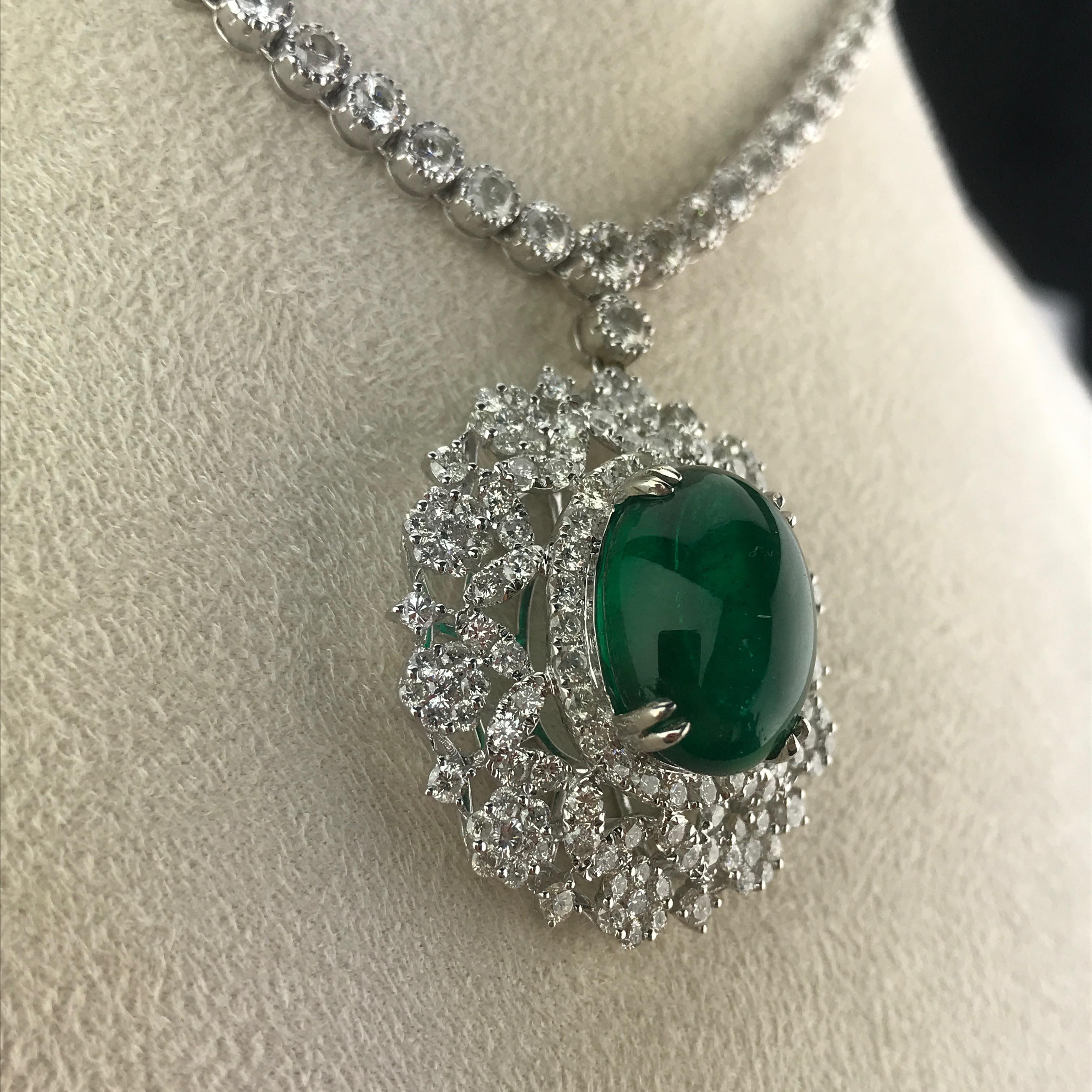 A statement necklace, with a beautiful, transparent and clean 15.03 carat Zambian Emerald  sorrounded with White Diamonds, hanging from a Diamond chain. The total necklace consists of over 11 carat of White DIamonds and is set in 18K White Gold. A