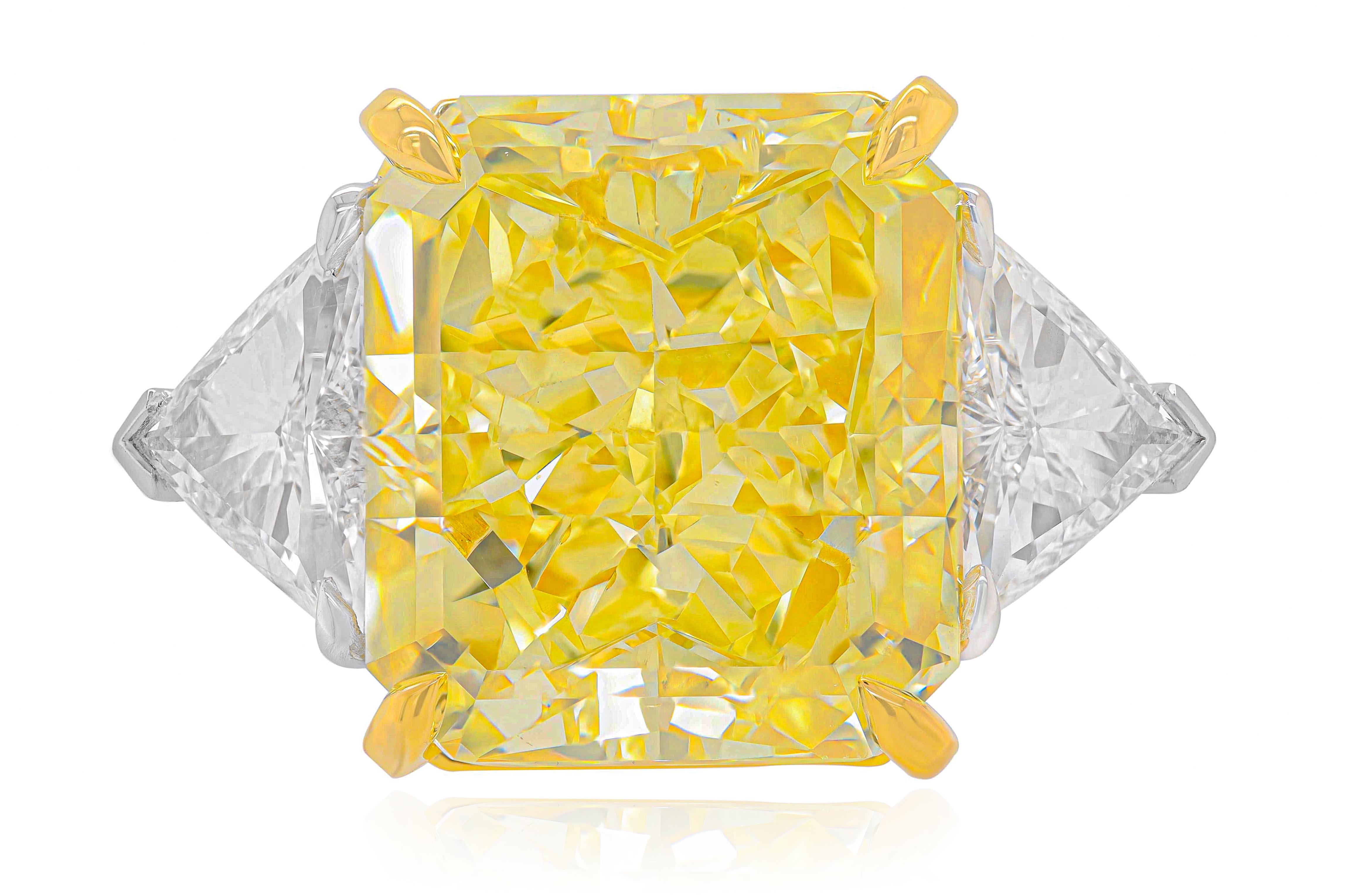 Magnificent platinum and 18kt yellow gold fancy yellow diamond engagement ring with center GIA certified 15.03 Carats Fancy Intense Yellow VS2 Radiant cut diamond set with two triangular, features 1.89 Carats  