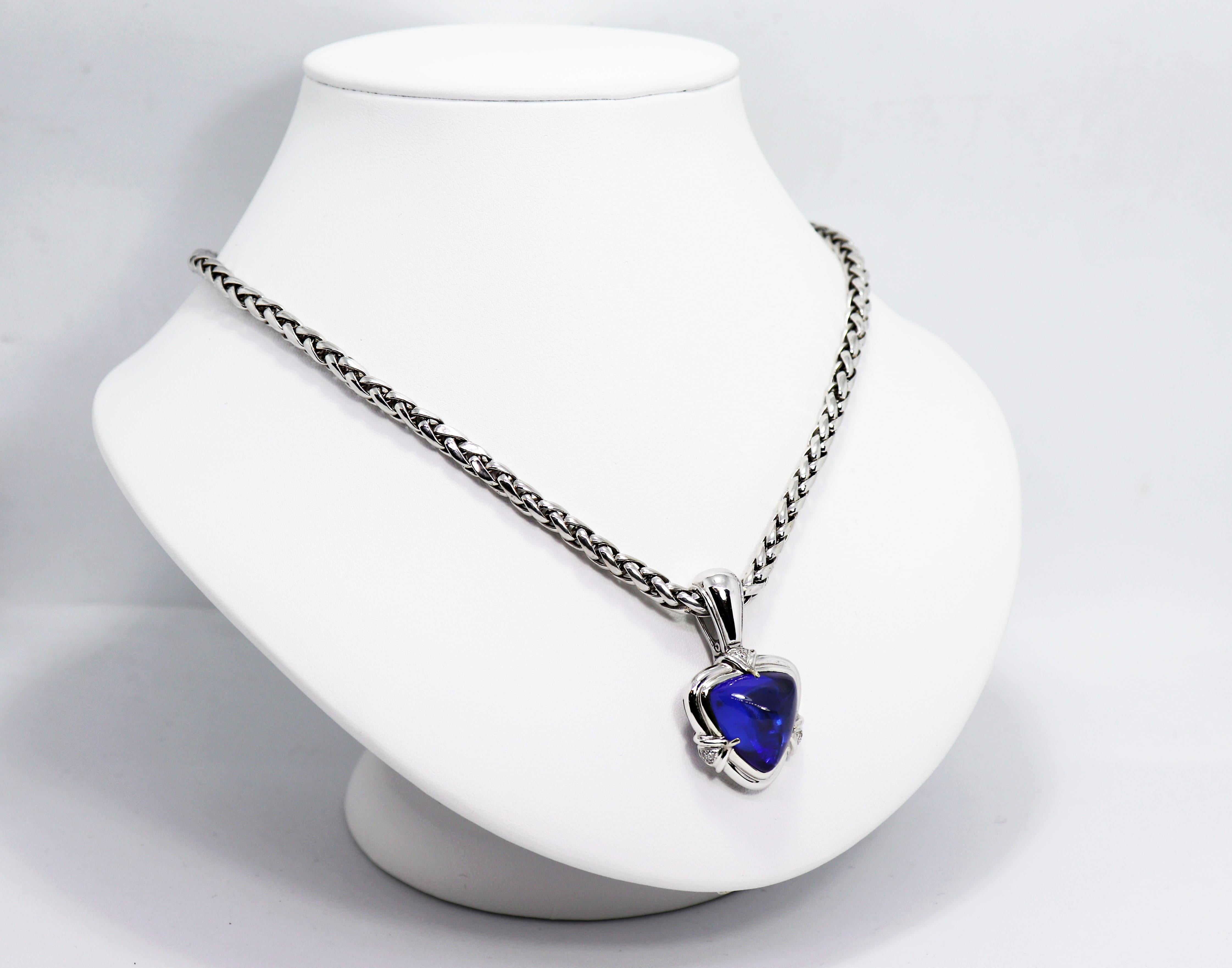 Beautiful necklace featuring a trillion shaped rare AAA+ grade vivid blue cabochon tanzanite weighing an impressive 15.05 carat in a rub-over, open back setting. The mount is further pavé set with nine brilliant cut diamonds weighing approximately
