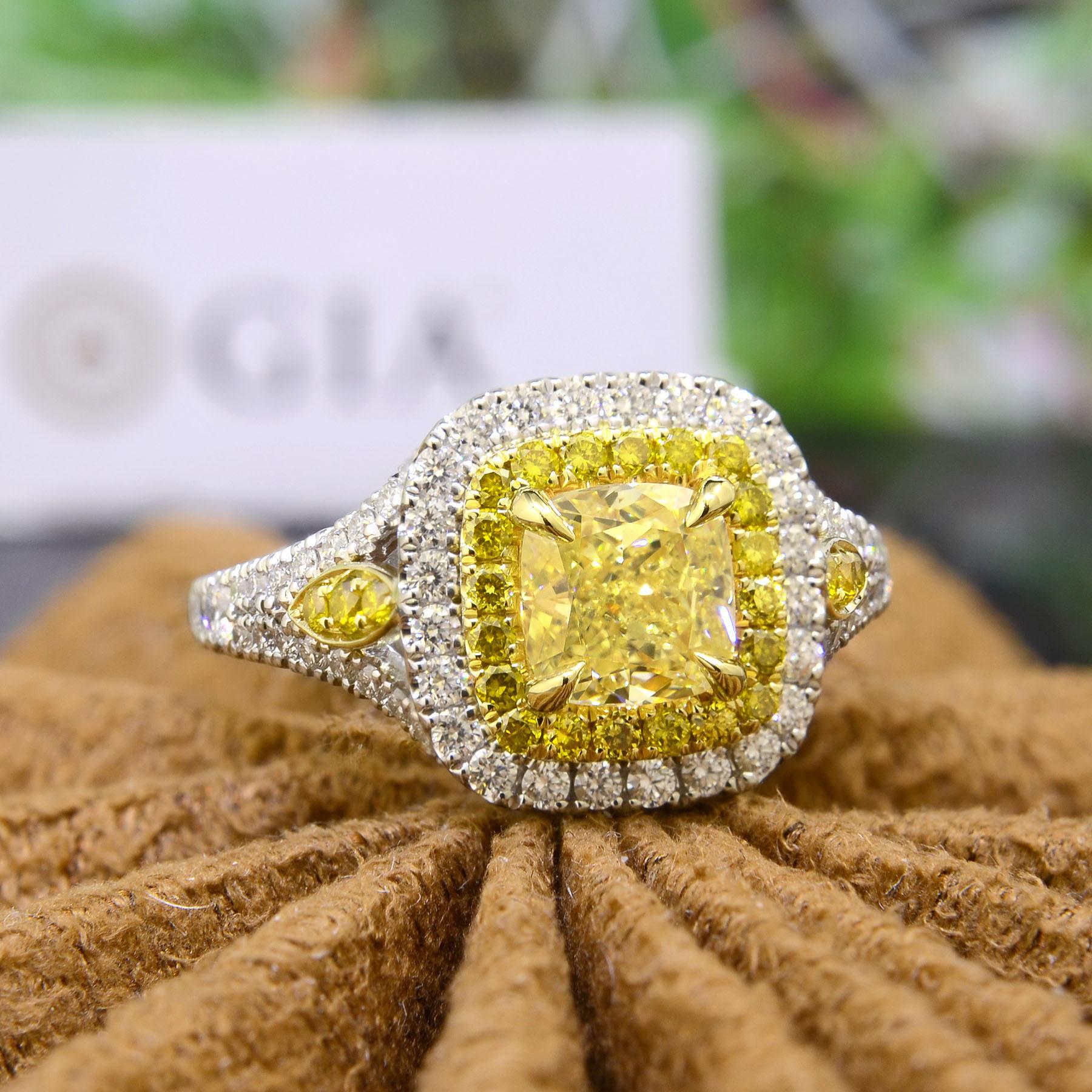 This dual halo diamond ring is created with a cushion cut yellow diamond center stone elaborately framed by round cut canary and white diamonds. The center stone is a lovely 1.00 Ct. Cushion cut canary diamond with natural fancy yellow color grade