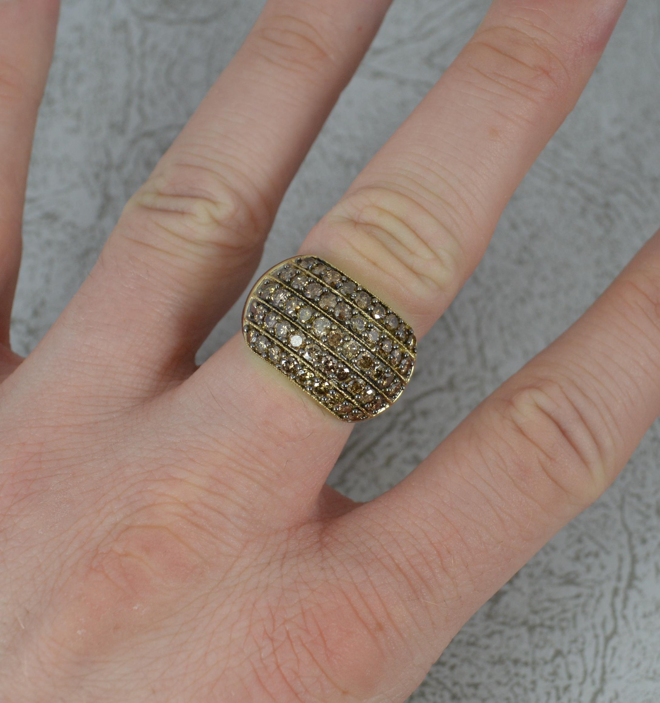 A 9 carat gold and diamond bling ring.
9ct yellow gold band and setting.
​Five row bombe shape, set with 1.50cts of natural round brilliant cut diamonds. Obvious champagne colour.
21mm x 14mm triple cluster head.

Condition ; Very good. Crisp