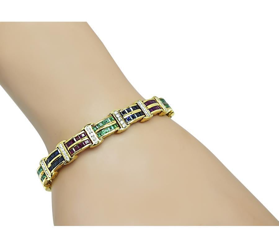 Si tratta di un elegante bracciale in oro giallo 18k. Il bracciale è incastonato con zaffiri, smeraldi e rubini dal taglio quadrato che pesano rispettivamente circa 1,60 ct, 1,20 ct e 1,60 ct. Le gemme preziose sono accentuate da scintillanti