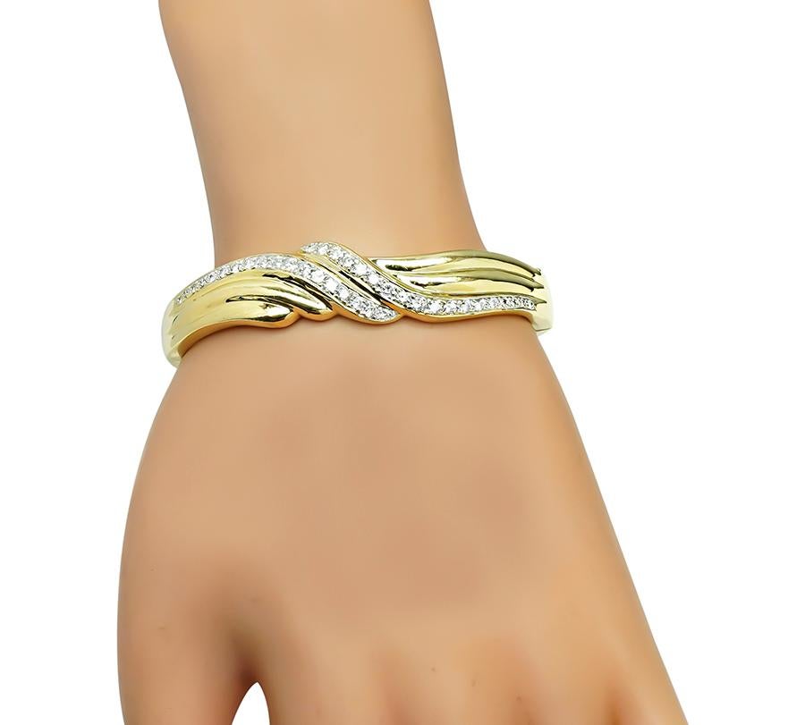 Questo è uno splendido braccialetto in oro giallo 14k. Il braccialetto è incastonato con scintillanti diamanti a taglio rotondo del peso di circa 1.50 carati. Il colore dei diamanti è H con purezza VS. Il braccialetto misura 14 mm di larghezza alla