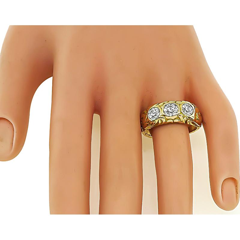 This is a fabulous 14k yellow gold ring. The ring is set with three sparkling old mine cut diamonds that weigh approximately 1.50ct. The color of these diamonds is G-H with VS clarity. The ring has a tapering width from 3mm to 9mm. The ring weighs