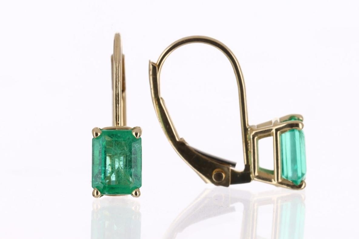 A simple pair of emerald cut-emerald lever back earrings made in 14K yellow gold. The chic pair of lever back earrings feature green, natural Emeralds. The emeralds have beautiful eye clarity, displaying minor flaws that are normal in all