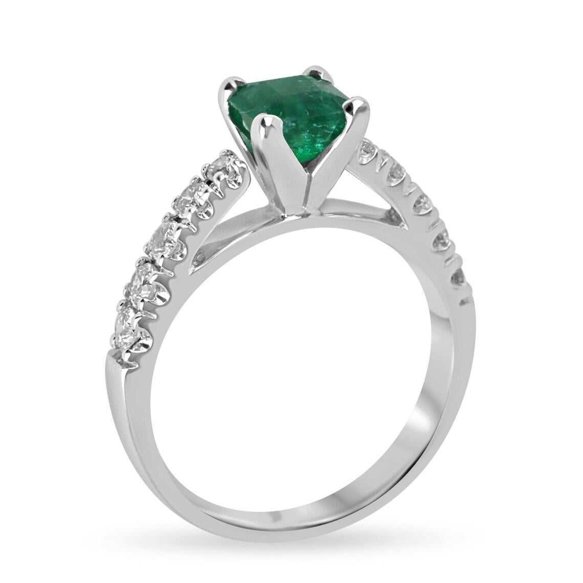 Este elegante anillo incluye una impresionante esmeralda talla Asscher de un intenso y profundo tono verde, engarzada con seguridad en una clásica montura de cuatro puntas. Acentuada por una hilera de brillantes diamantes de talla redonda a lo largo