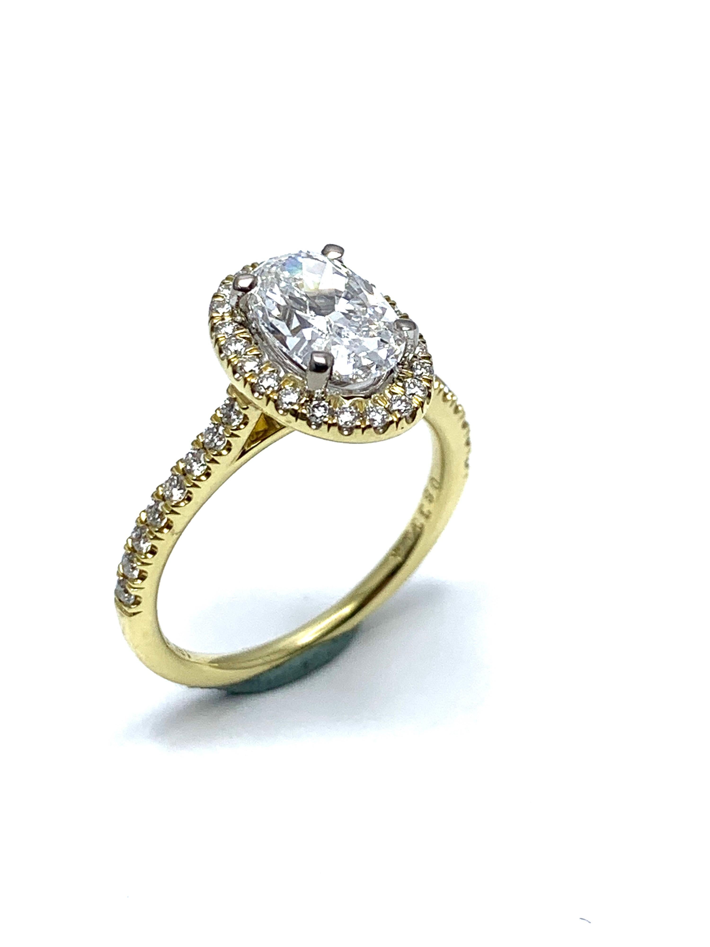 A gorgeous 1.51 carat oval brilliant Diamond 18 karat yellow gold ring.  The oval brilliant Diamond is set in four prongs atop a single row of round brilliant Diamonds surrounding, and a Diamond half shank.  The oval Diamond is garded by GIA report