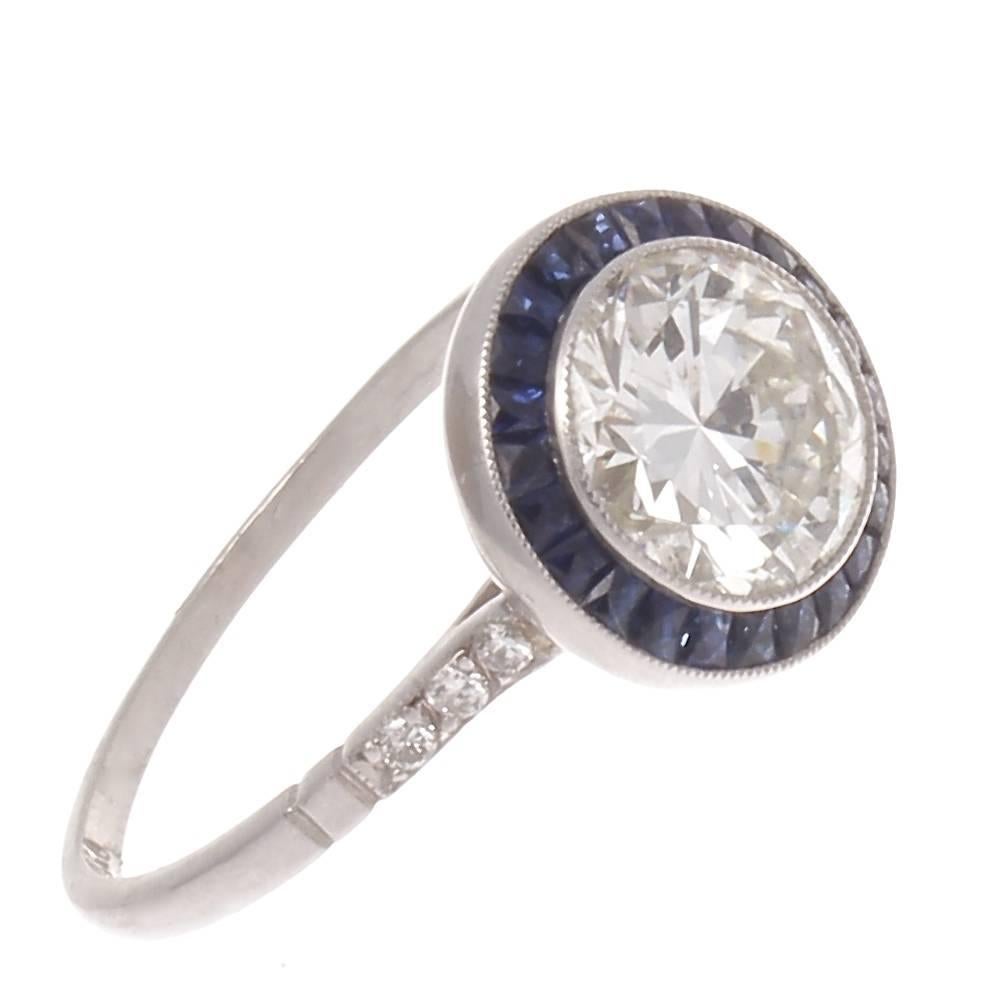 An engagement ring that is as timeless as a good marriage. Steeped in the tradition of the romantic and elegant art deco era, it is still very relevant to this day.  Designed with a 1.51 carat lively white diamond set in a sparkling sapphire halo