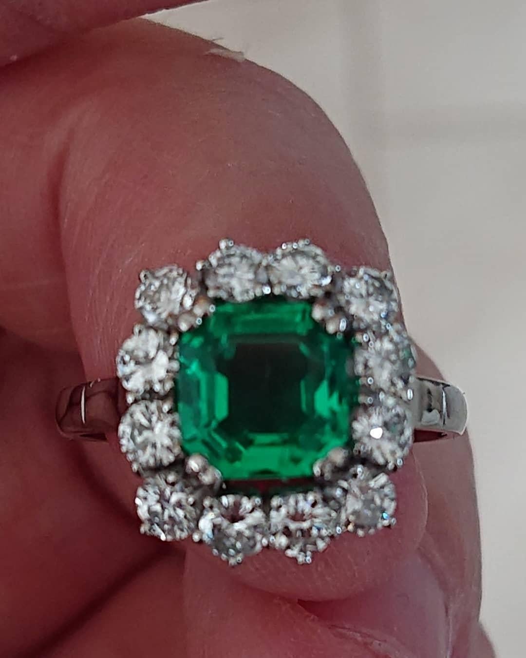 A 1.51 Carats Colombian Emerald Diamond and Platinum Cluster Ring With Certificate. The beautiful rectangular emerald with Gem and Pearl Laboratory certificate stating it to be from Colombia and with minor traces of oil. In a surround of white
