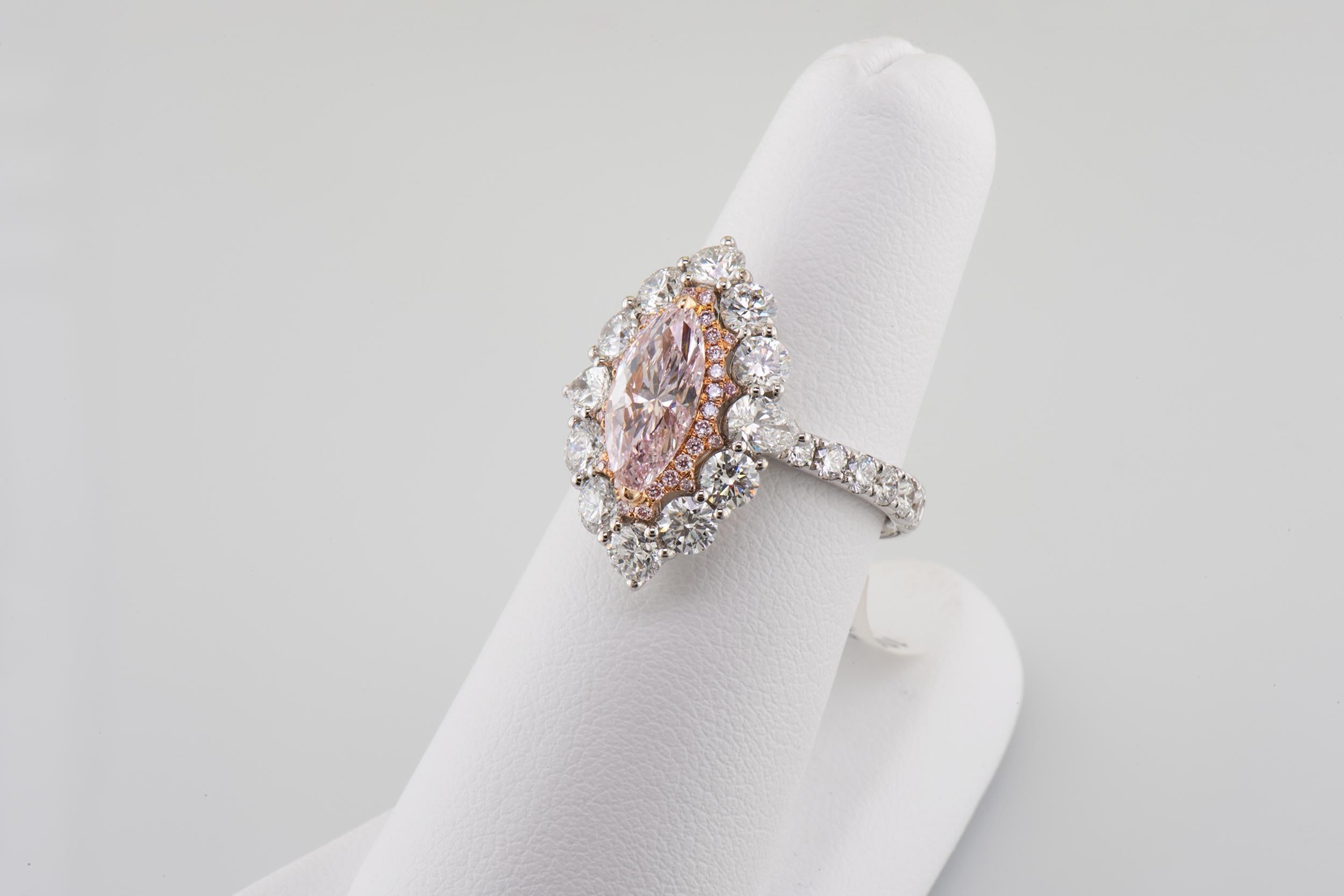 Designed to sparkle for a lifetime, this exquisite natural pink marquis-cut diamond is wrapped in a frame of smaller pink diamonds set in rose gold. Crafted in 18k white gold, the elegant outer halo sets off the bright pink center and sits atop a