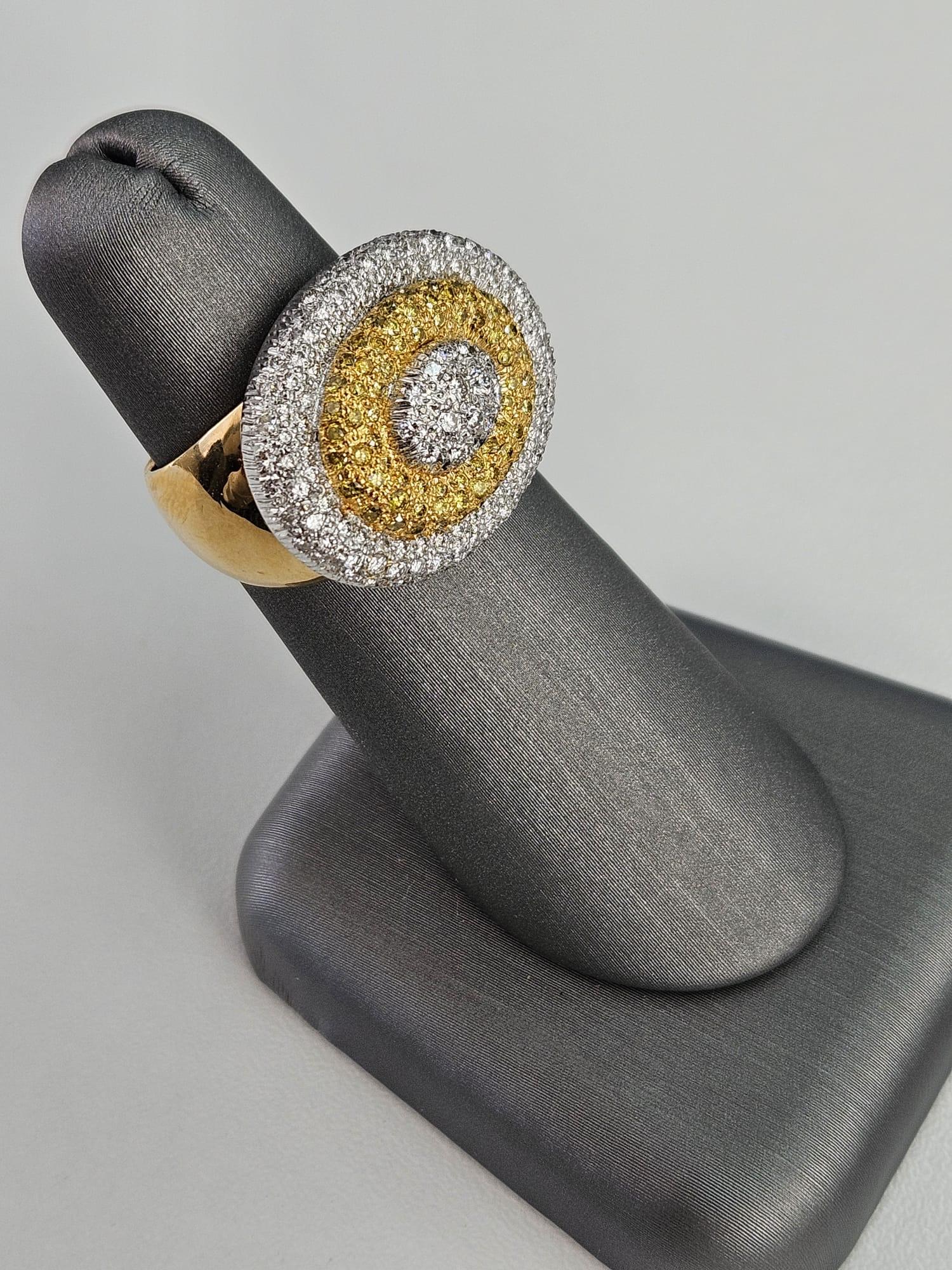 Presenting an extraordinary 1.51 carat Canary Diamond band ring, where the union of vivid yellow and sparkling white diamonds forms an exquisite pattern of nested ovals. This captivating piece showcases a 0.55-carat Canary Diamond and a 0.96-carat