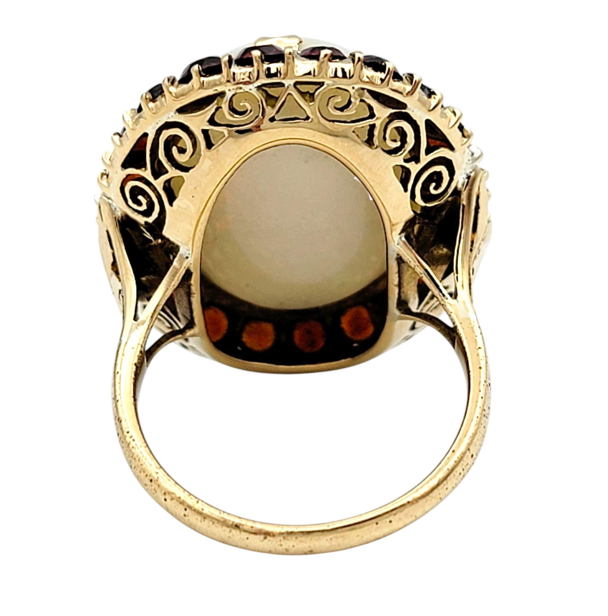 Women's 15.12 Carat Oval Cabochon Opal Cocktail Ring with Garnet Halo in 14 Karat Gold For Sale
