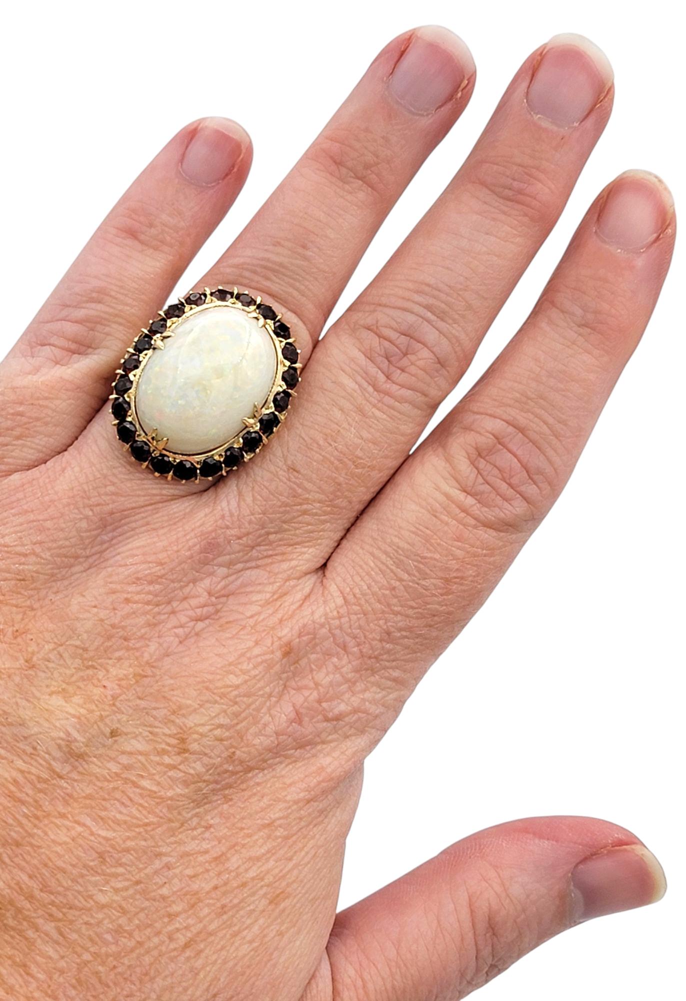 15.12 Carat Oval Cabochon Opal Cocktail Ring with Garnet Halo in 14 Karat Gold For Sale 1