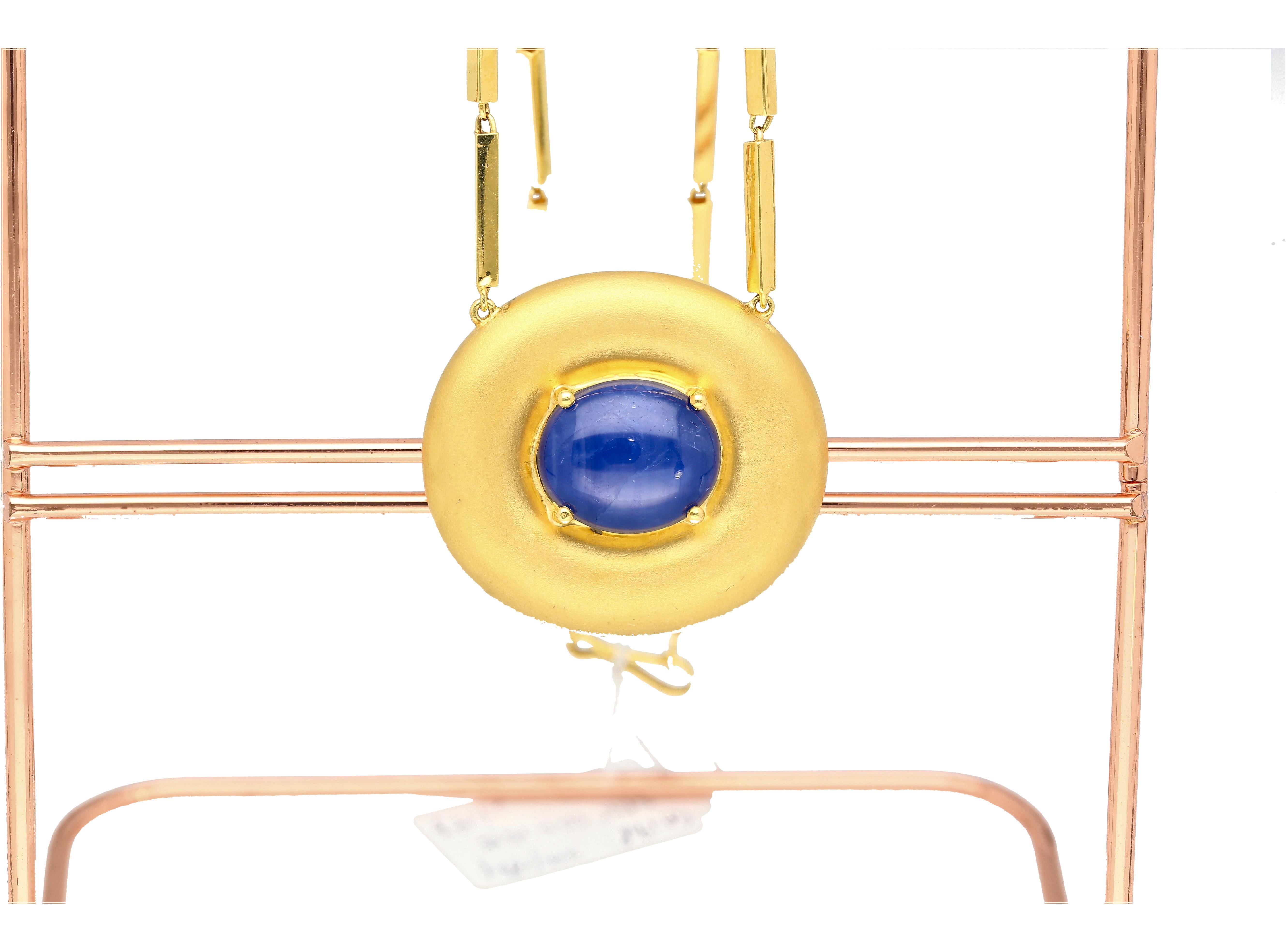 Questa splendida collana con ciondolo a forma di stella in oro giallo 18 carati e 22 carati presenta uno zaffiro blu a forma di stella incastonato in un solitario da 15,15 carati con taglio ovale. Questo zaffiro a stella è incastonato in una