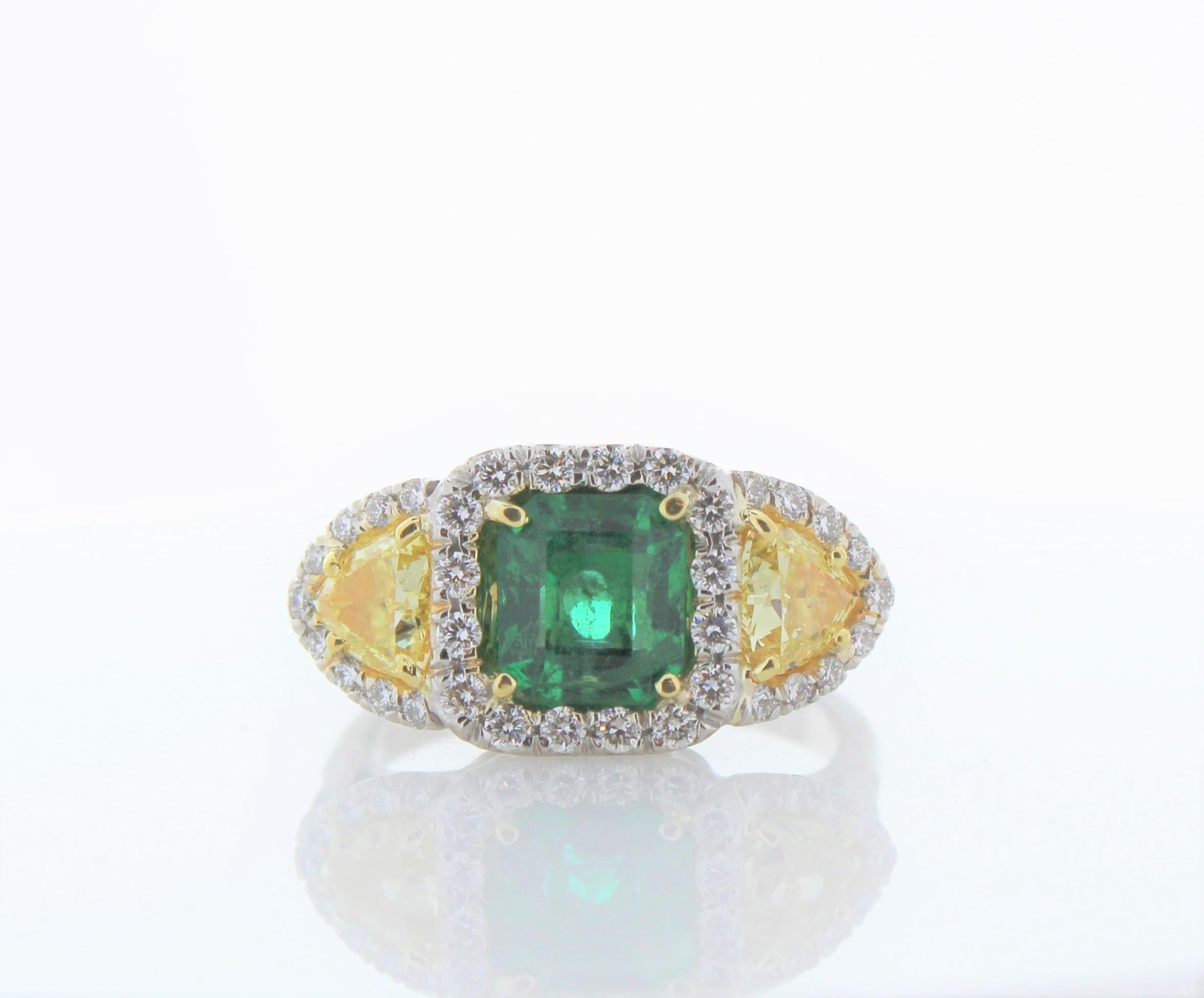 This ring features a deep grass green 1.52 carats. Its color is evenly distributed throughout the gem. Highlighting the majestic central emerald are two yellow diamonds and round brilliant diamonds totaling up to 1.67 carats. Set in platinum, this
