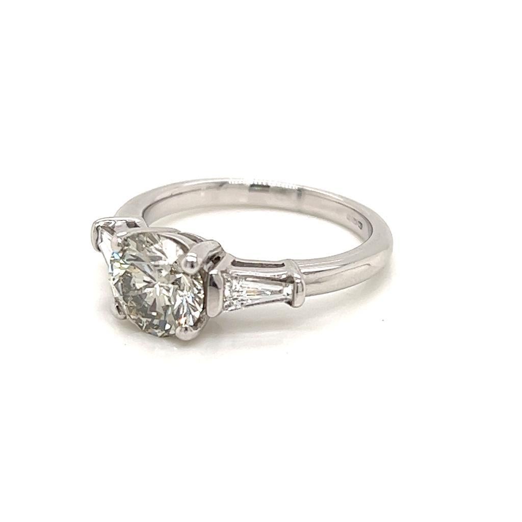 1.52 Carat Round Brilliant Diamond with Tapered Side Diamonds Platinum Ring

This glamorous three-stone ring features a magnificent 1.52 carat round brilliant Diamond at its centre. This jewel is held in a claw setting on a Platinum ring, and is of