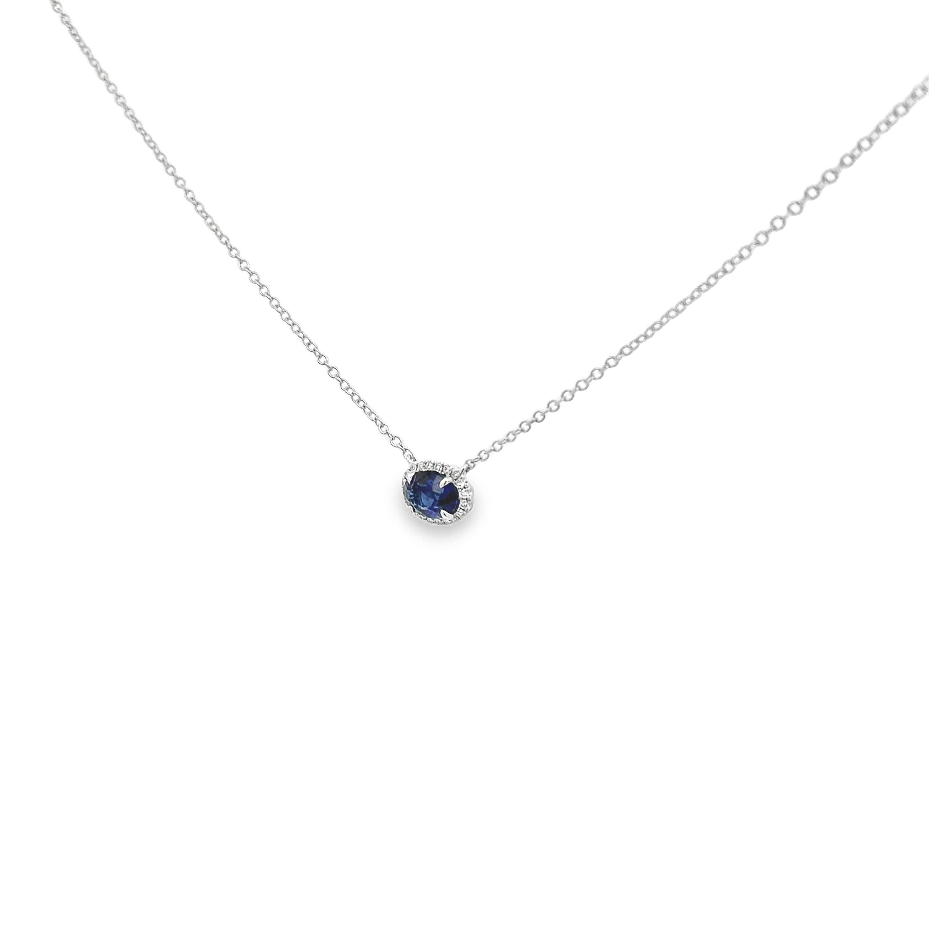 A beautiful pendant necklace, featuring a 1.52 carats oval cut sapphire, set on a four prong setting in a horizontal composition. Accented by a halo of round cut diamonds weighing 0.12 carat total, set on a micropavé setting. Finely made with 18K