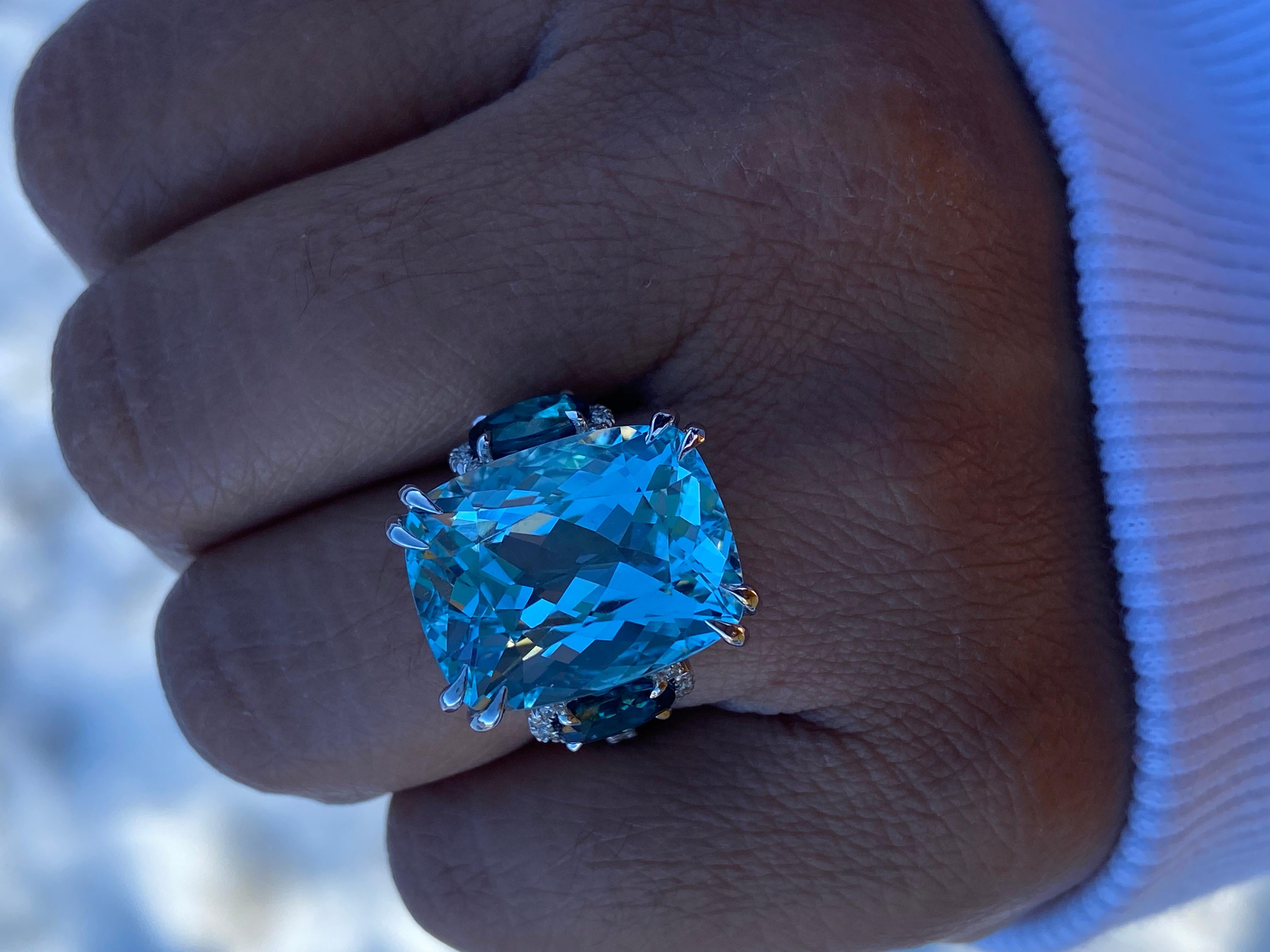 A 15.23ct Aquamarine is joined by two Indigo Tourmalines totaling 1.88 carats and numerous round diamonds. Crafted in 18K white gold ring. GIA certified.