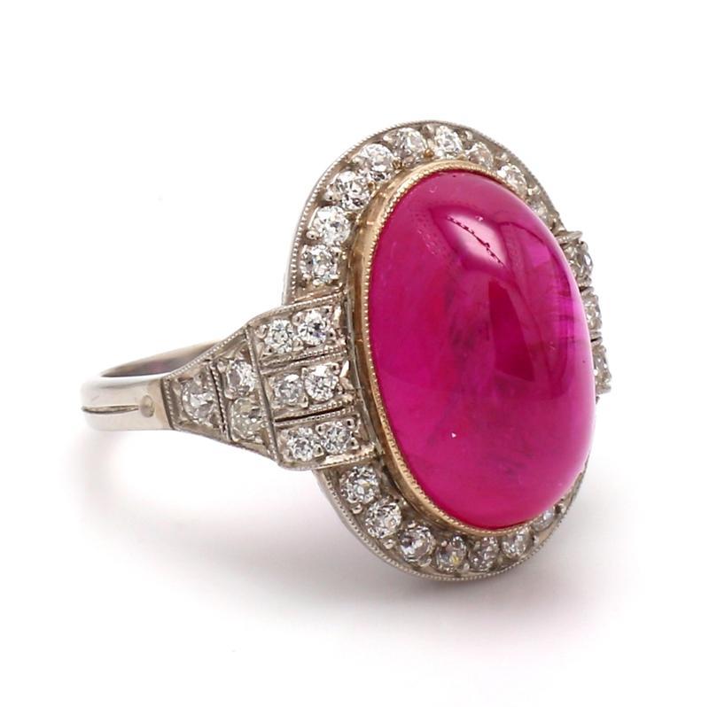 Platinum and 18K yellow gold, cocktail ring.  Center stone is one (1) oval, pyramidal cabochon cut ruby weighing 15.25ct. Ruby is accompanied by AGL Prestige Gemstone Report #CS1076454. Ring is set with thirty-six (36) round brilliant cut diamonds