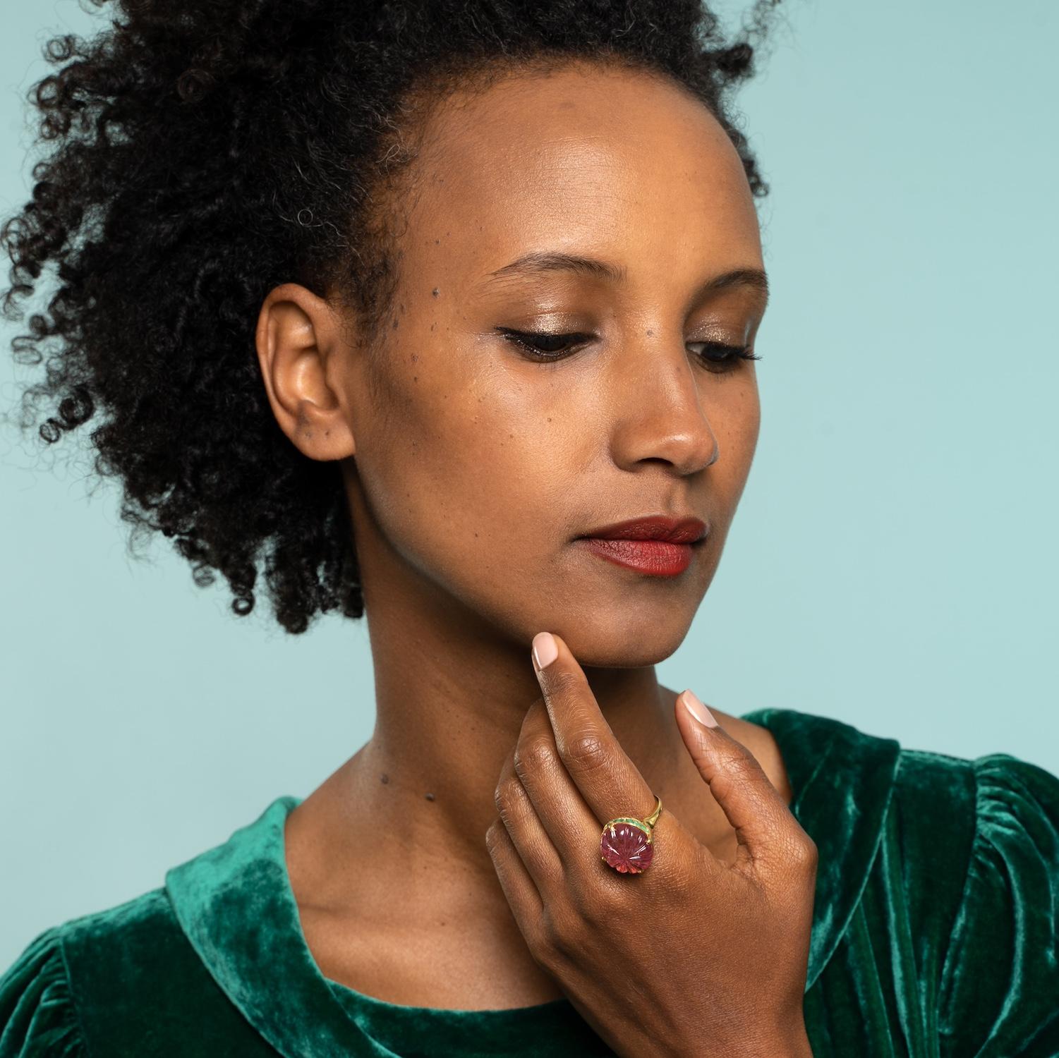 

This spectacular one-of-a-kind tourmaline and emerald gold cocktail ring, has been handmade in our workshops. The ring features a 15.25k pink tourmaline, which has been hand-carved and is surrounded by emeralds. The ring is made in 18k gold and