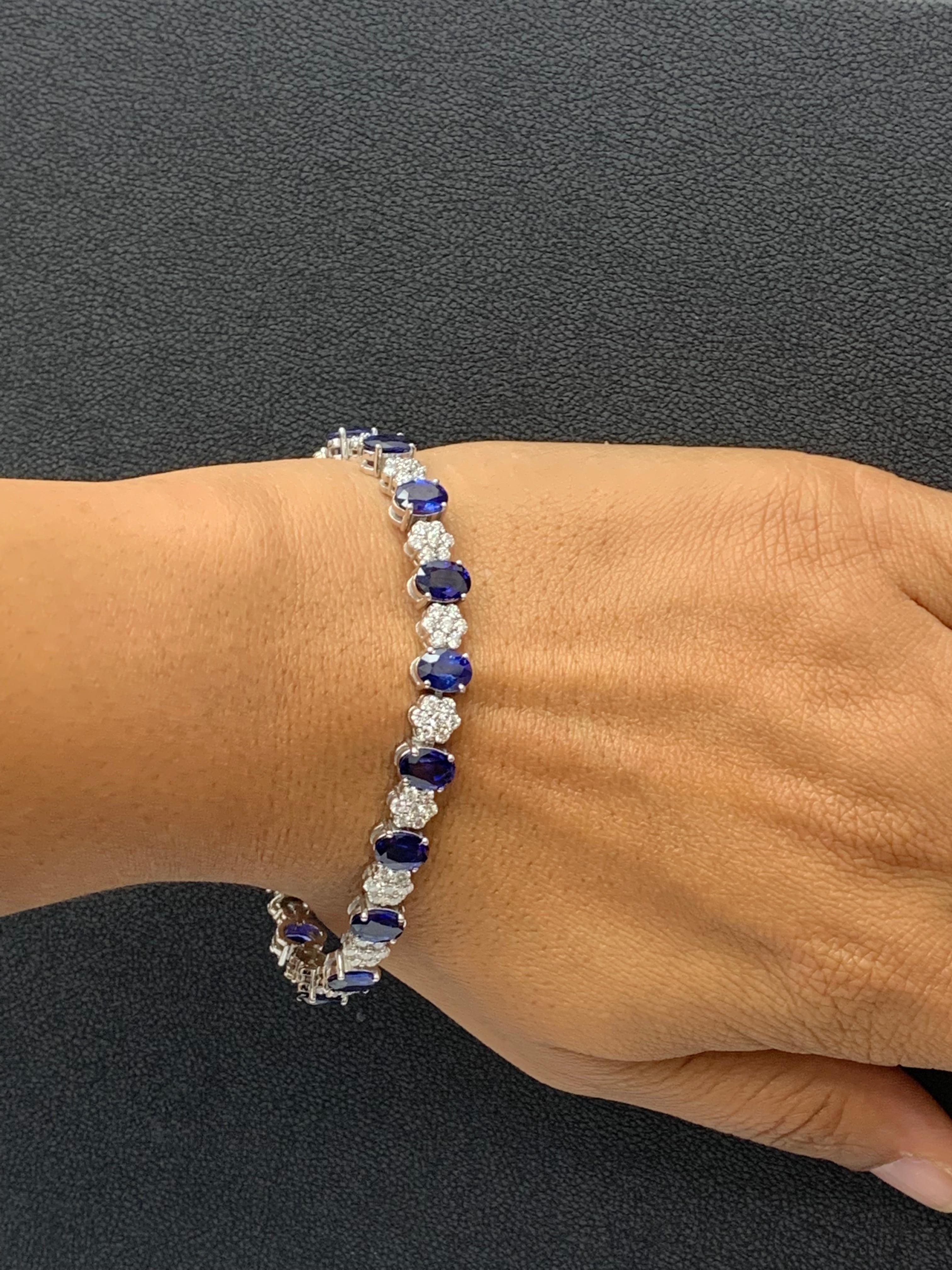 A fashionable and color-rich tennis bracelet showcasing oval cut 17 Blue Sapphires weighing 15.26 carats total, spaced by 119 flower shape round brilliant diamonds weighing 3.16 carats total. Made in 14k white gold.

All diamonds are GH color SI1