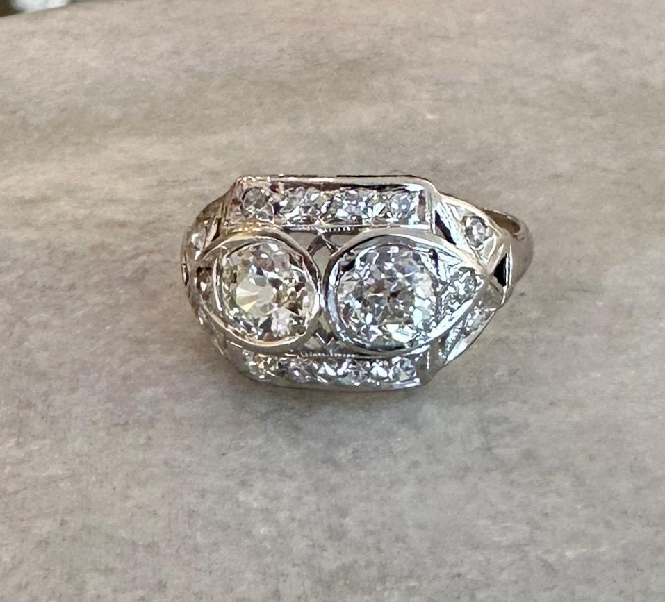 Impresionante anillo antiguo de los años 20
Dos diamantes brillantes talla europea antigua
1,08 ct
I-K Color  Claridad SI-I
.44ct Diamantes redondos talla antigua 
H-J Color  Claridad SI-I 
2,6 gramos Platino
Talla 6.75 y es considerable
La parte
