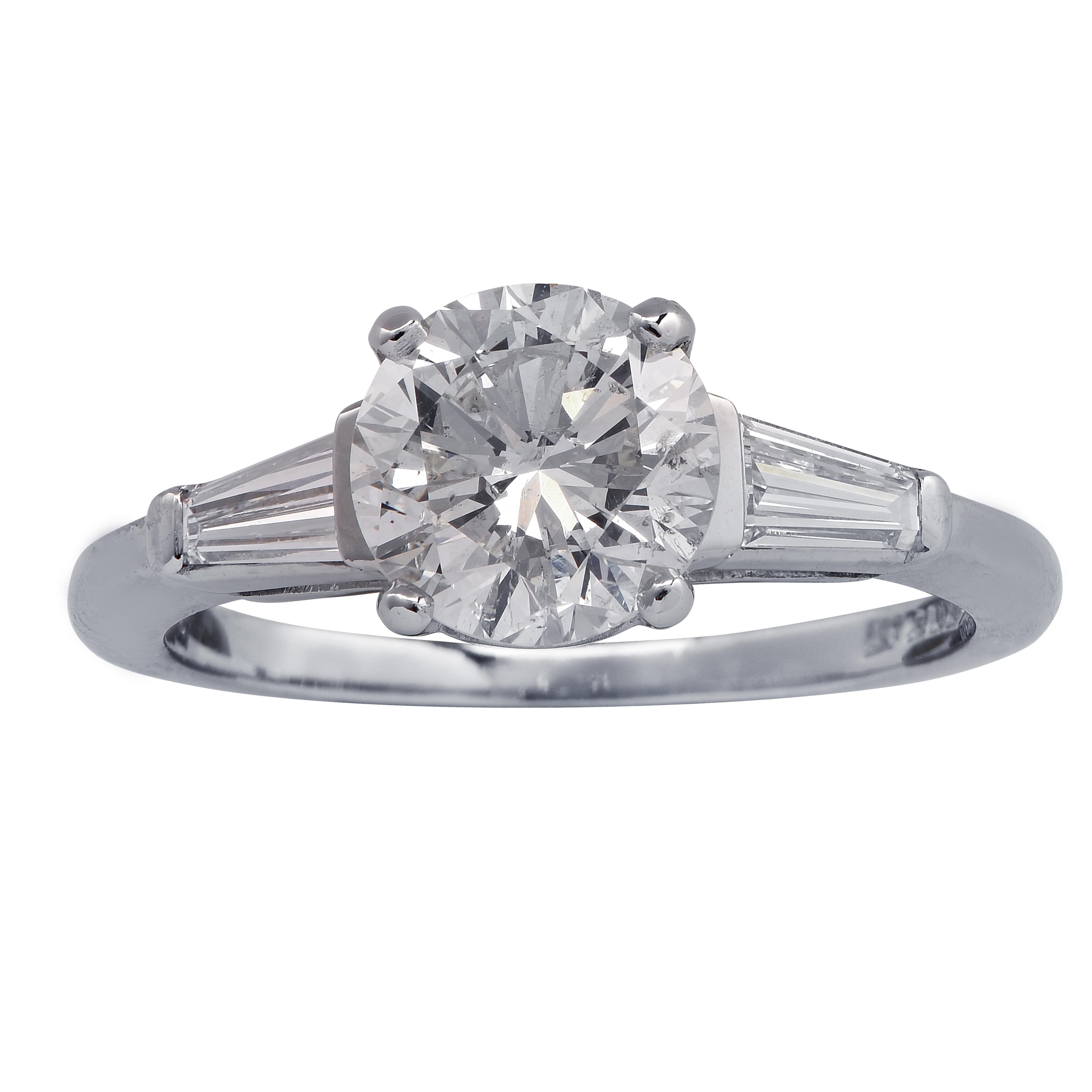 Stunning engagement ring crafted in platinum, showcasing a round brilliant cut diamond weighing 1.53 carats, I color, Si2 clarity, adorned with 2 tapered baguette cut diamonds weighing approximately .30 carats total G color VS clarity. The band