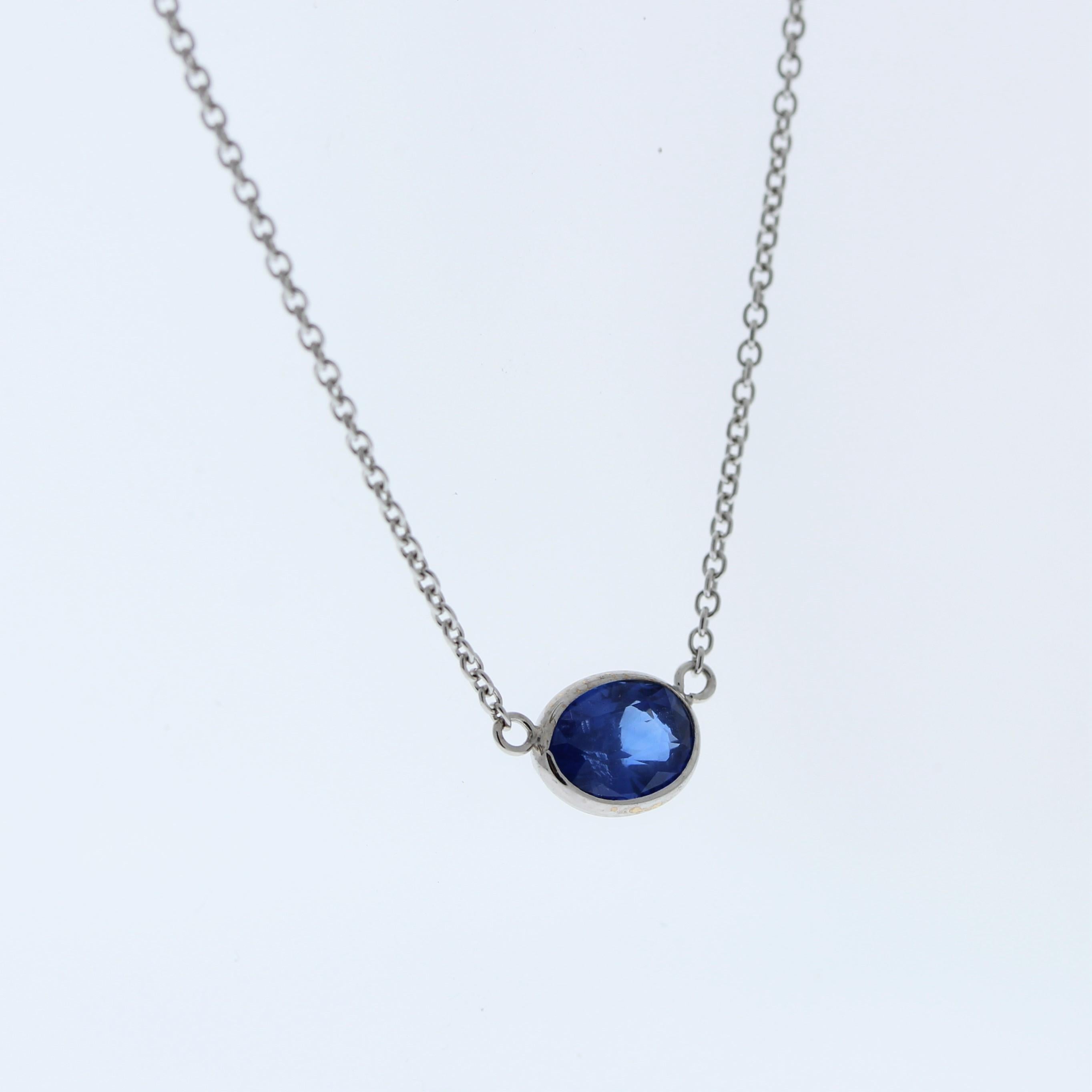 The necklace features a 1.53-carat oval-cut blue sapphire set in a 14 karat white gold pendant or setting. The oval cut and the blue sapphire's color against the white gold setting are likely to create an elegant and versatile fashion piece,