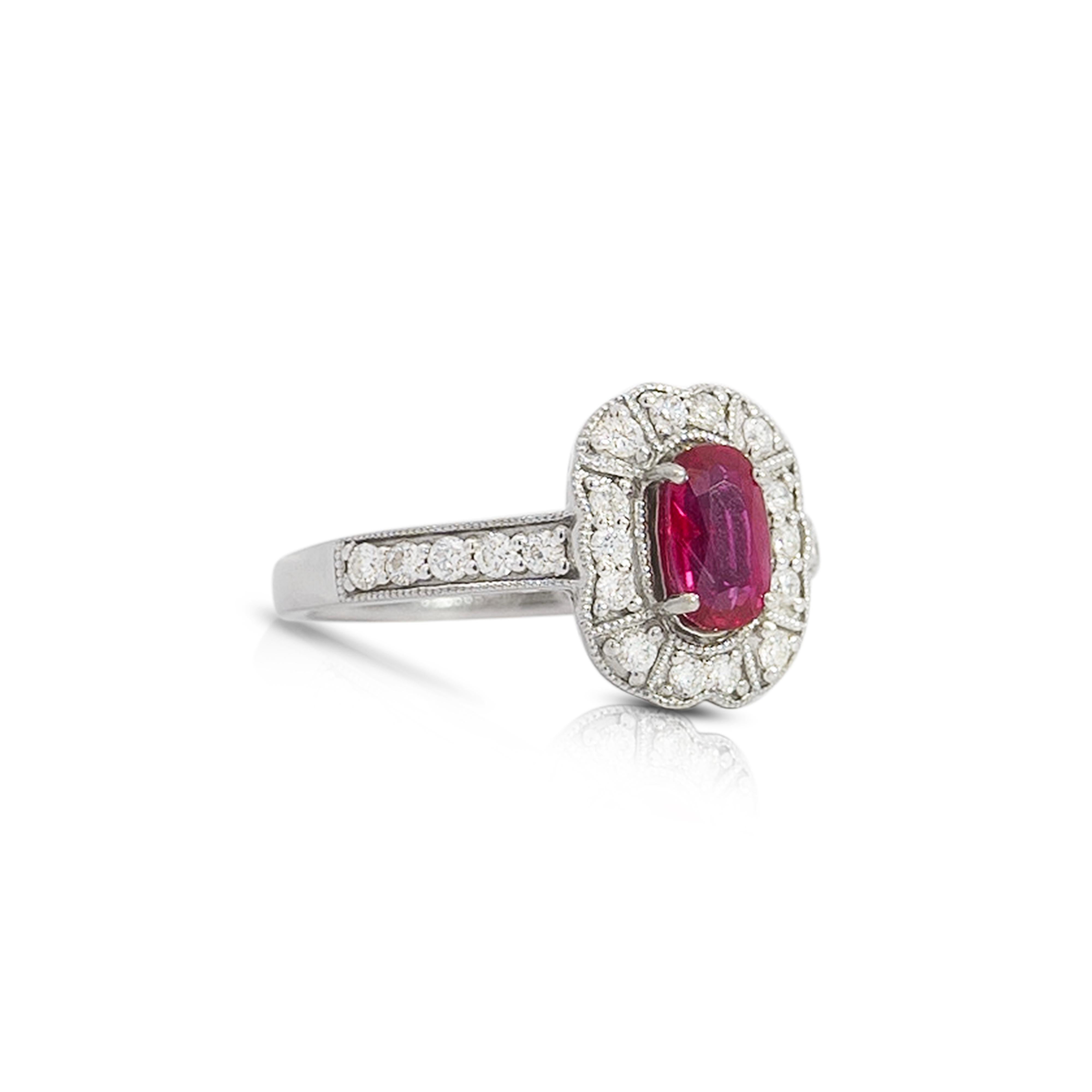 This is a Vintage Ruby and Diamond Ring. This ring showcases an unheated, 1.09 carat, oval cut prong set Ruby at the center. The Ruby is surrounded by 14 round cut diamonds, with another 10 diamonds on the band, 0.44 CTTW. The diamonds are graded
