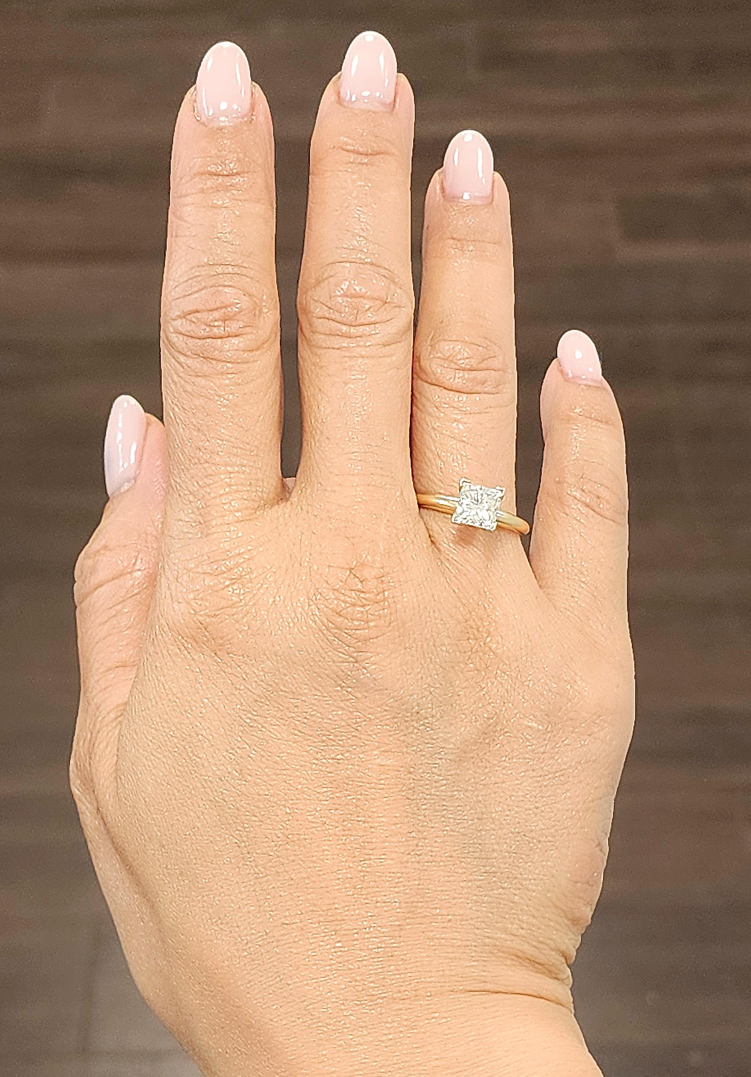 Découvrez cette bague de mariage exquise. La bague met en valeur un diamant de taille princesse de 1,53 ct de couleur blanche. Le diamant présente une pureté VS1 et une couleur J. Fabriquée en or jaune 14k, cette pièce moderne est originaire des