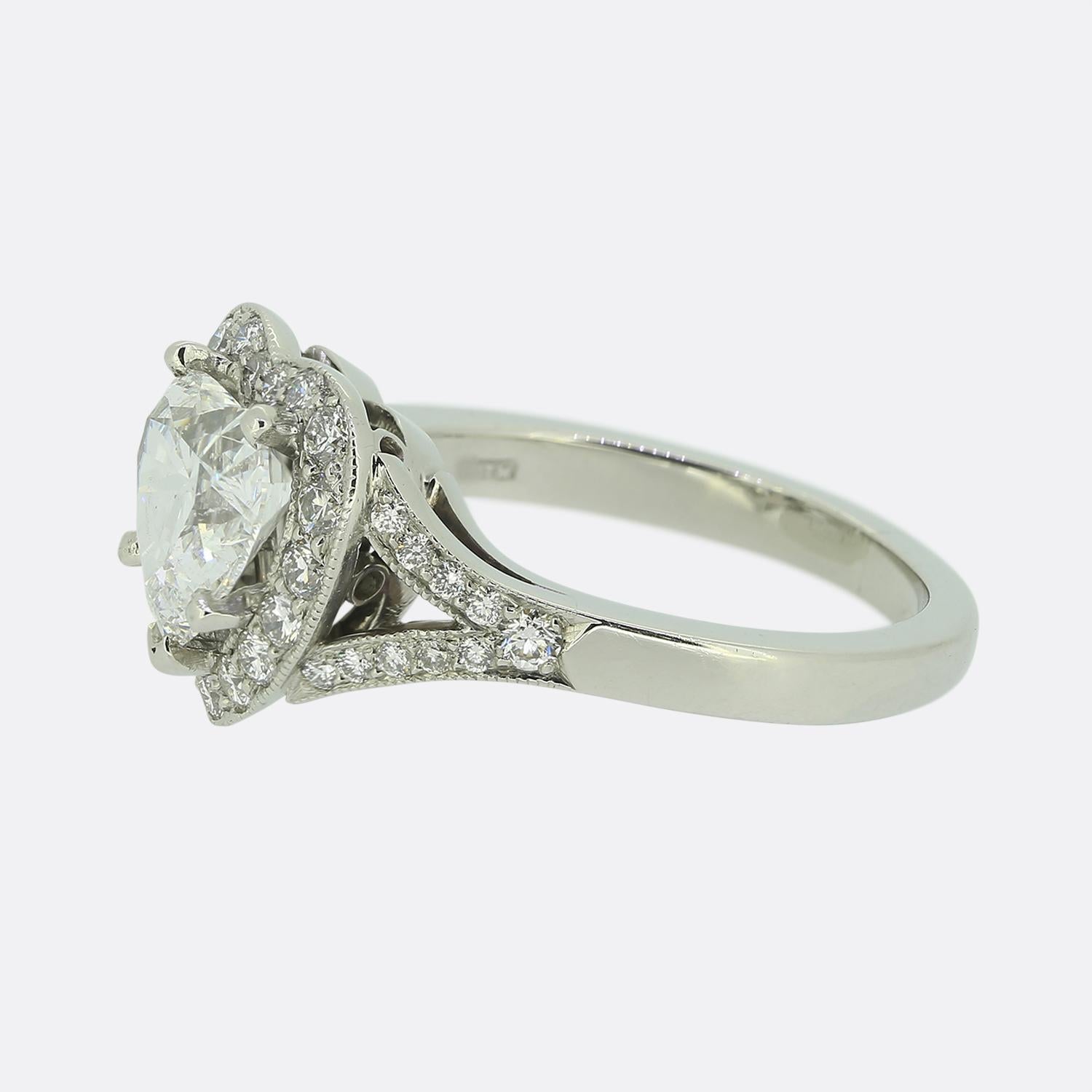 Nous avons ici une délicieuse bague en forme de cœur. Au centre se trouve un diamant en forme de cœur, taillé de manière experte, qui est légèrement surélevé et entouré d'une bordure de diamants ronds de taille brillante. Des pierres blanches
