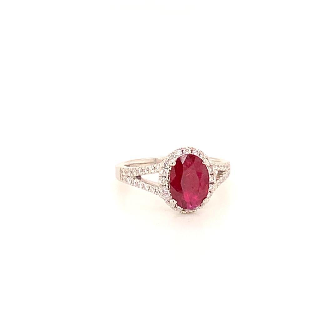 This elegantly stunning ring features a beautifully radiant Oval cut 1.54 Carat blood red Ruby surrounded by a halo of glittering diamonds set in a diamond encrusted band of Platinum. The gleaming diamonds in this gorgeous ring weigh approximately