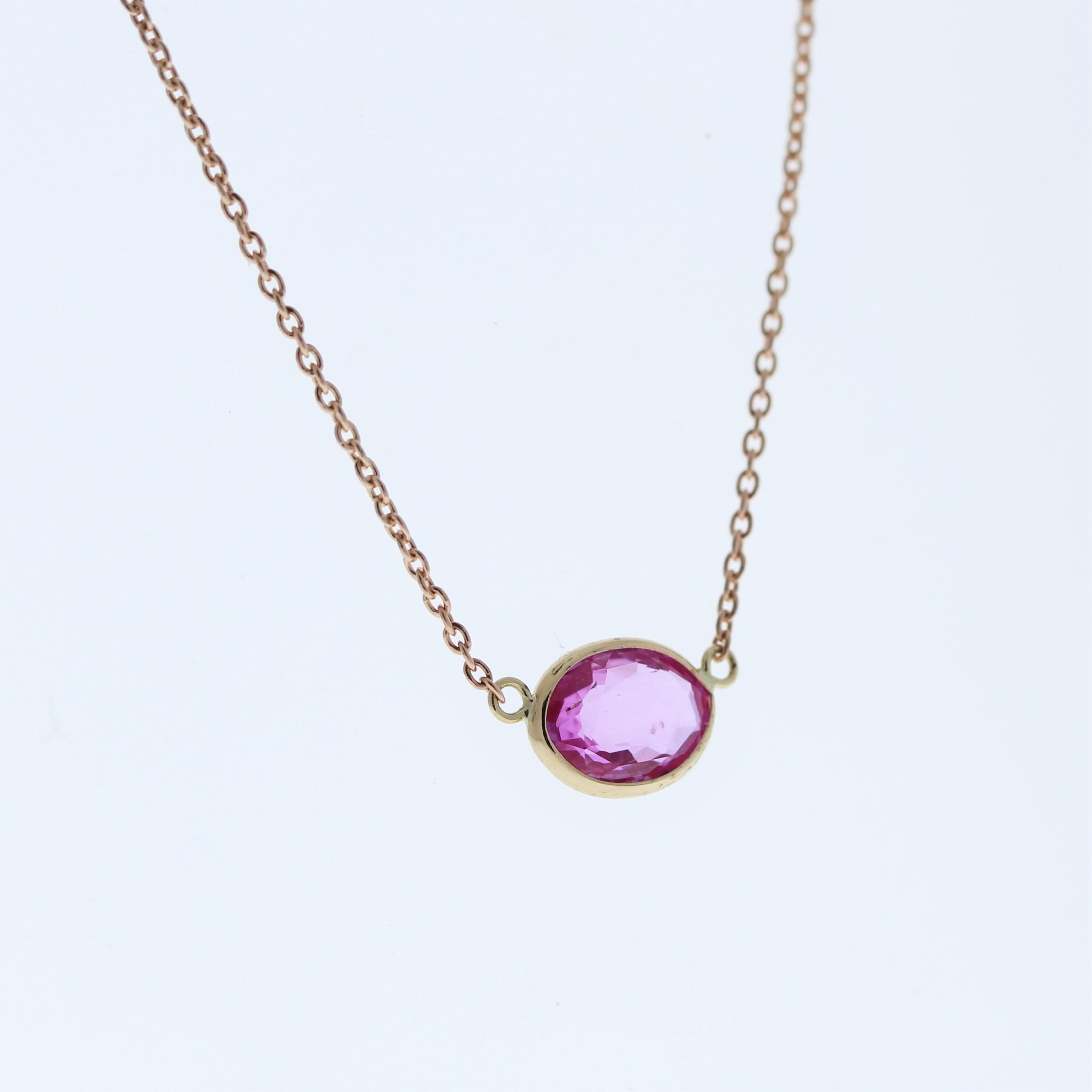 The necklace features a 1.54-carat oval-cut pink sapphire set in a 14 karat rose gold pendant or setting. The oval cut and the pink sapphire's color against the rose gold setting are likely to create a romantic and elegant fashion piece, suitable