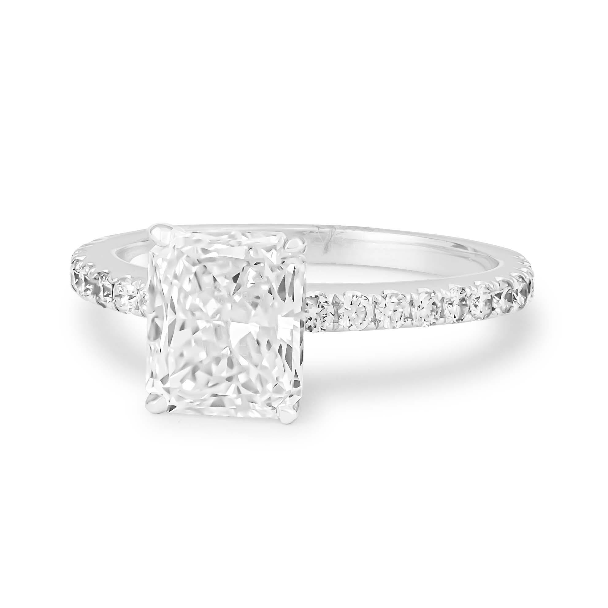 Stunning EGL certified 1.54 carat radiant cut diamond engagement ring that has been beautifully set in a 4-prong, 18K white gold basket head. The center diamond is adorned by 0.33 carats of fine round brilliant cut diamonds that are perfectly set